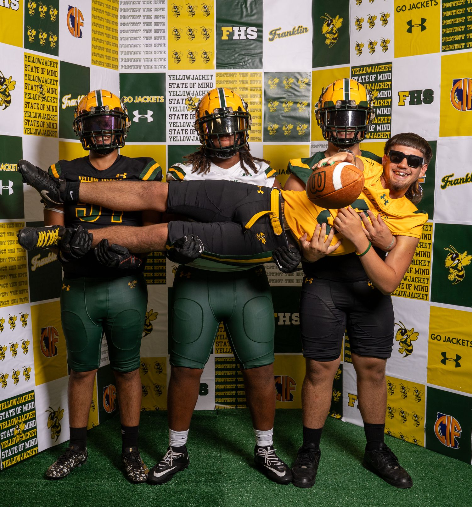 Franklin High School Yellow Jackets football players pose in uniform at FHS media day photo booth.