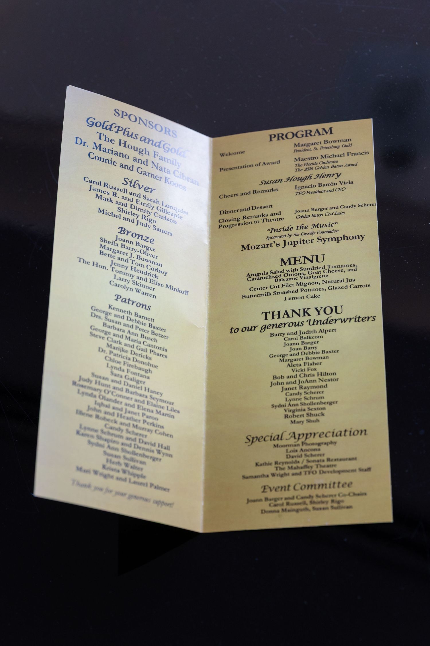 Event program booklet showing sponsors, menu featuring Mozart Jupiter Symphony, and thank you to underwriters.