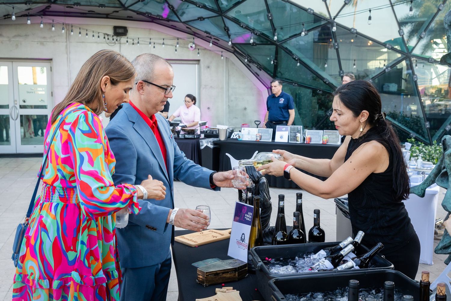 Guests sample wines from an outdoor bar at an elegant wine tasting event.
