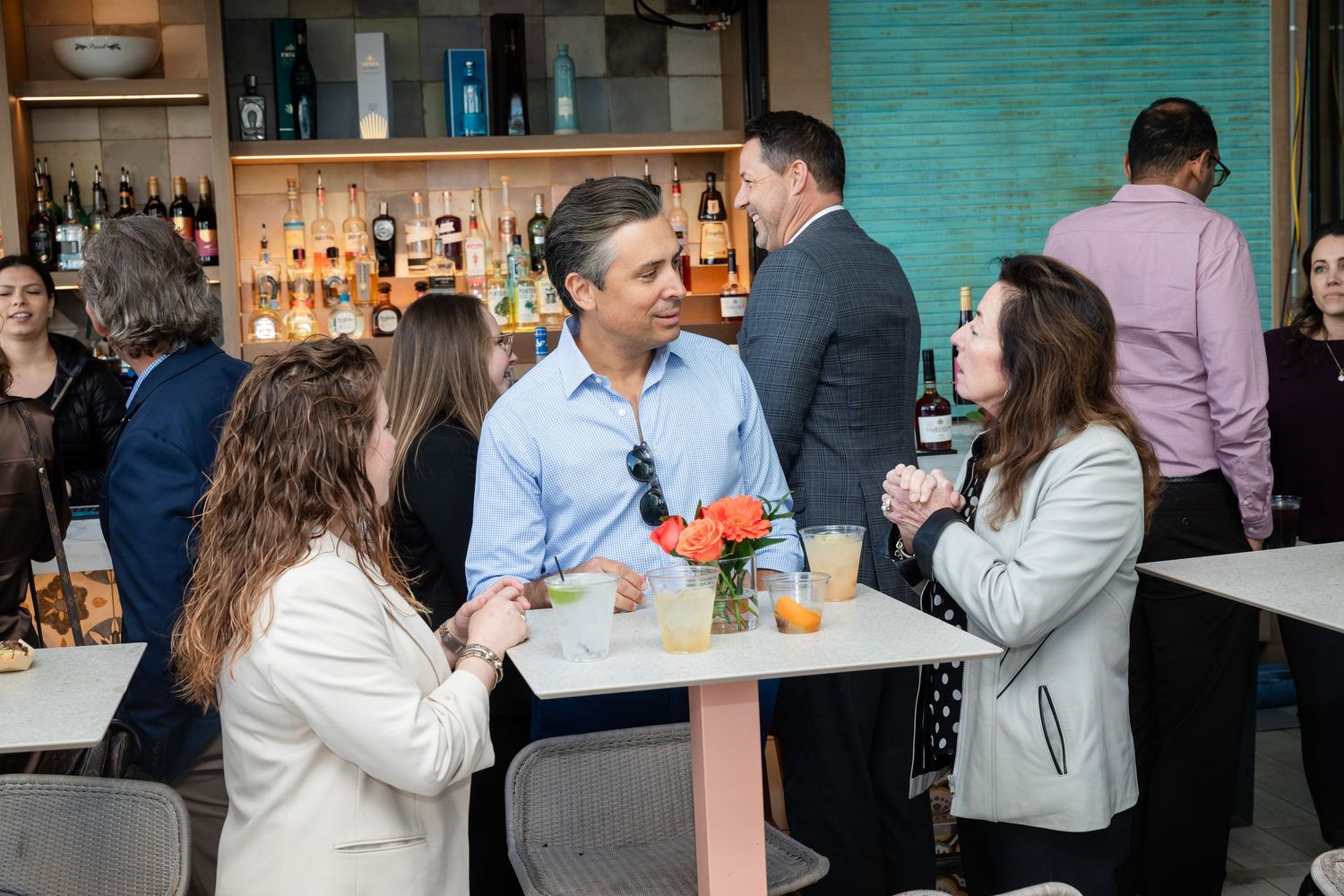 Group of professionals mingling and networking at a bar venue during a business event.