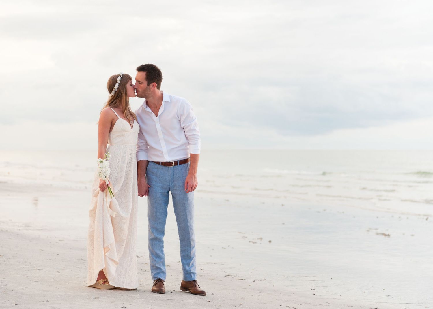 Bride and groom share a romantic kiss on the beach after their wedding on Treasure Island, Florida.