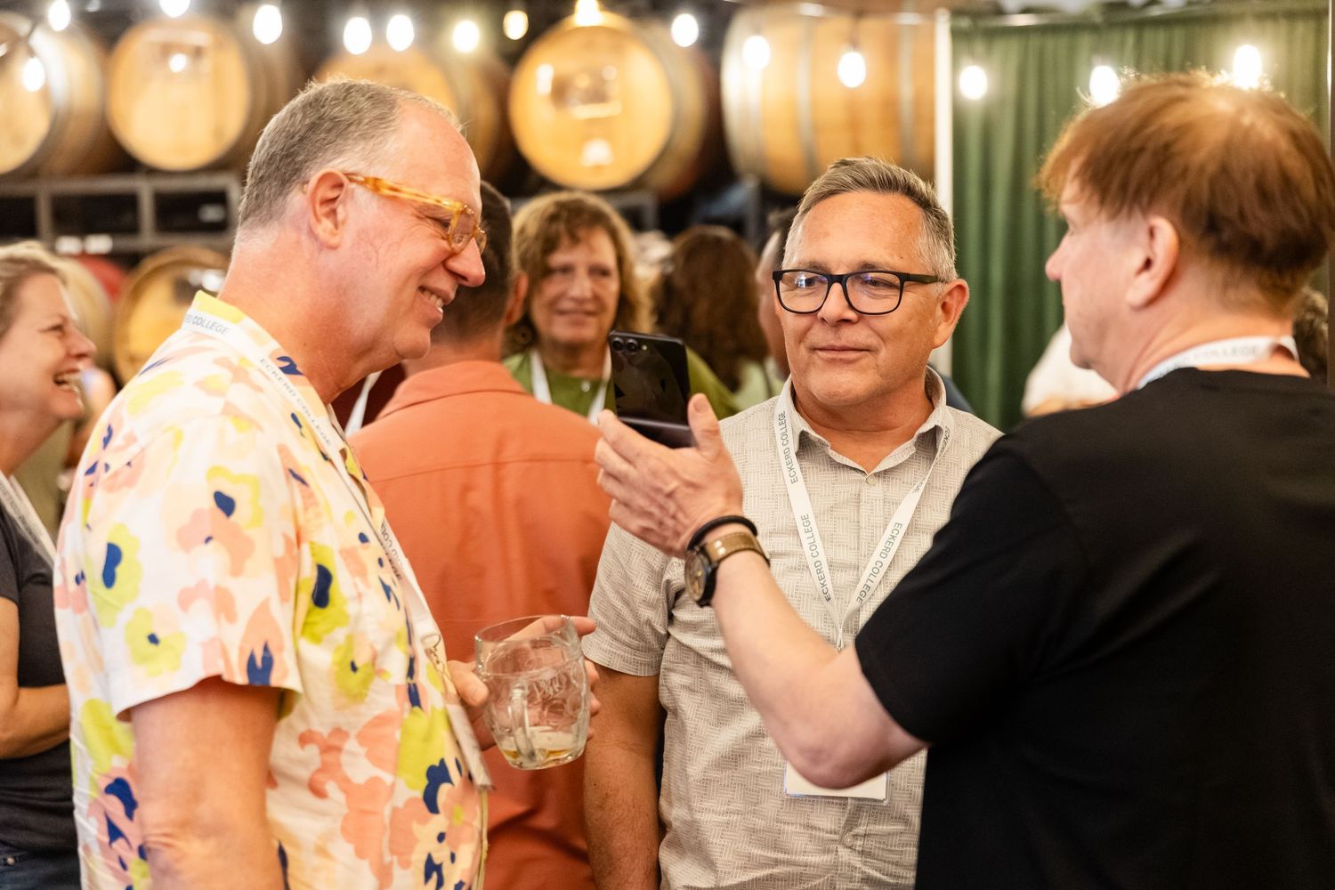 Group of adults enjoying drinks and conversation at an indoor brewery networking event.