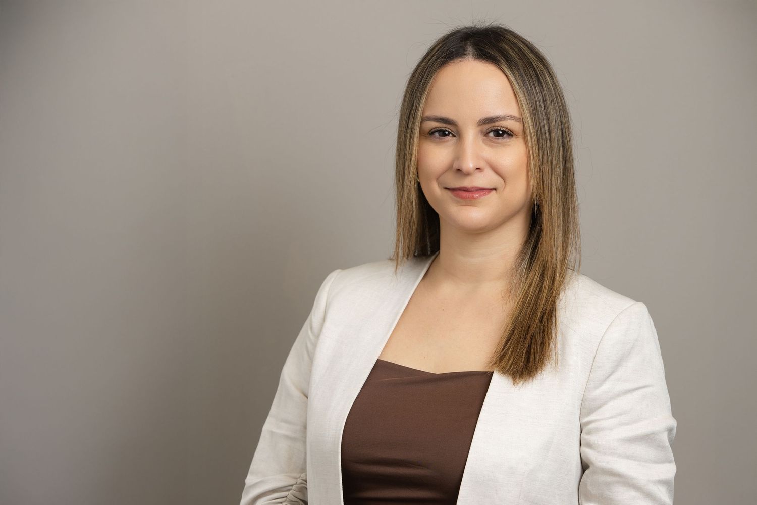 Corporate headshot of businesswoman against neutral studio backdrop