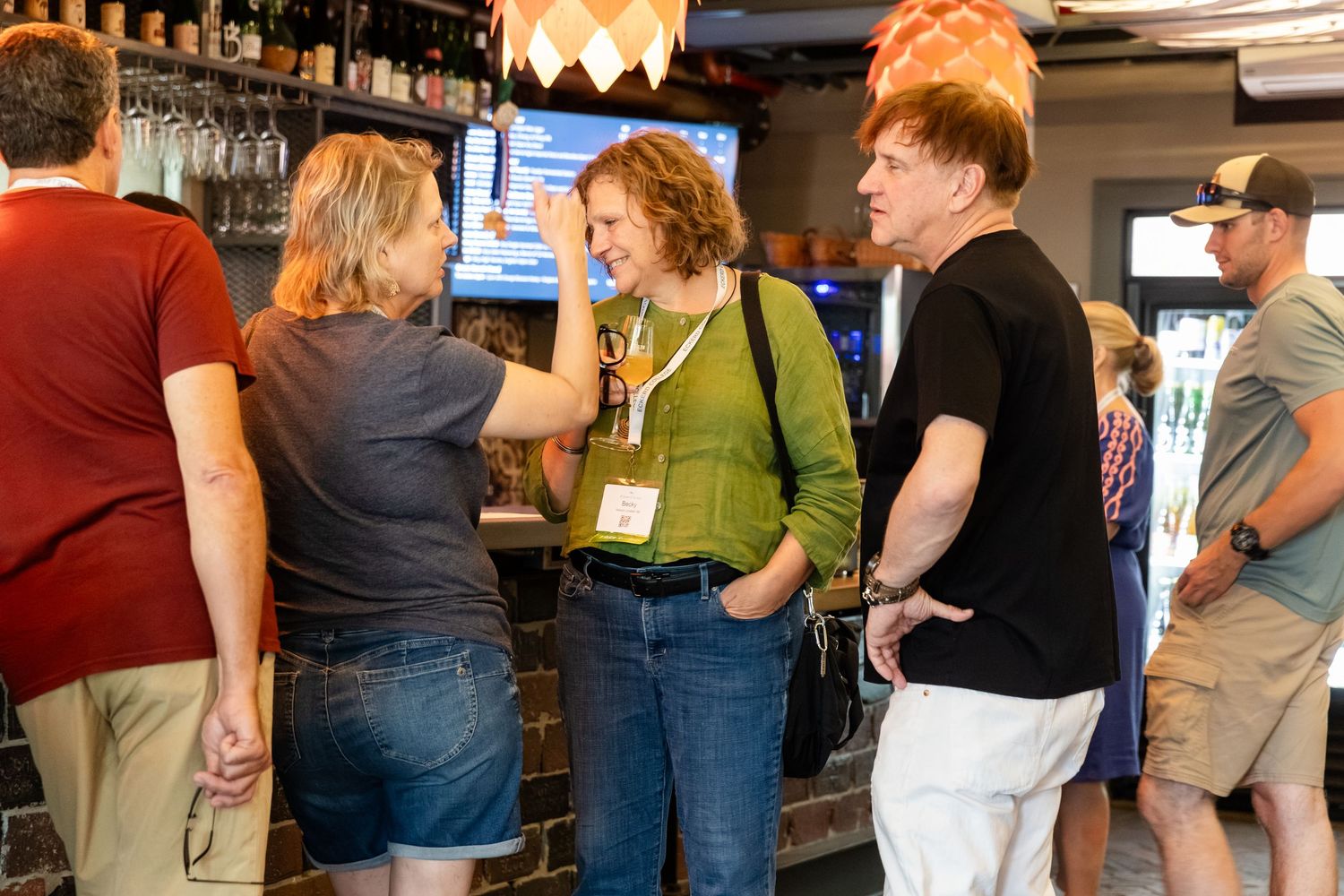 People networking and conversing at a bar during a social mixer event.