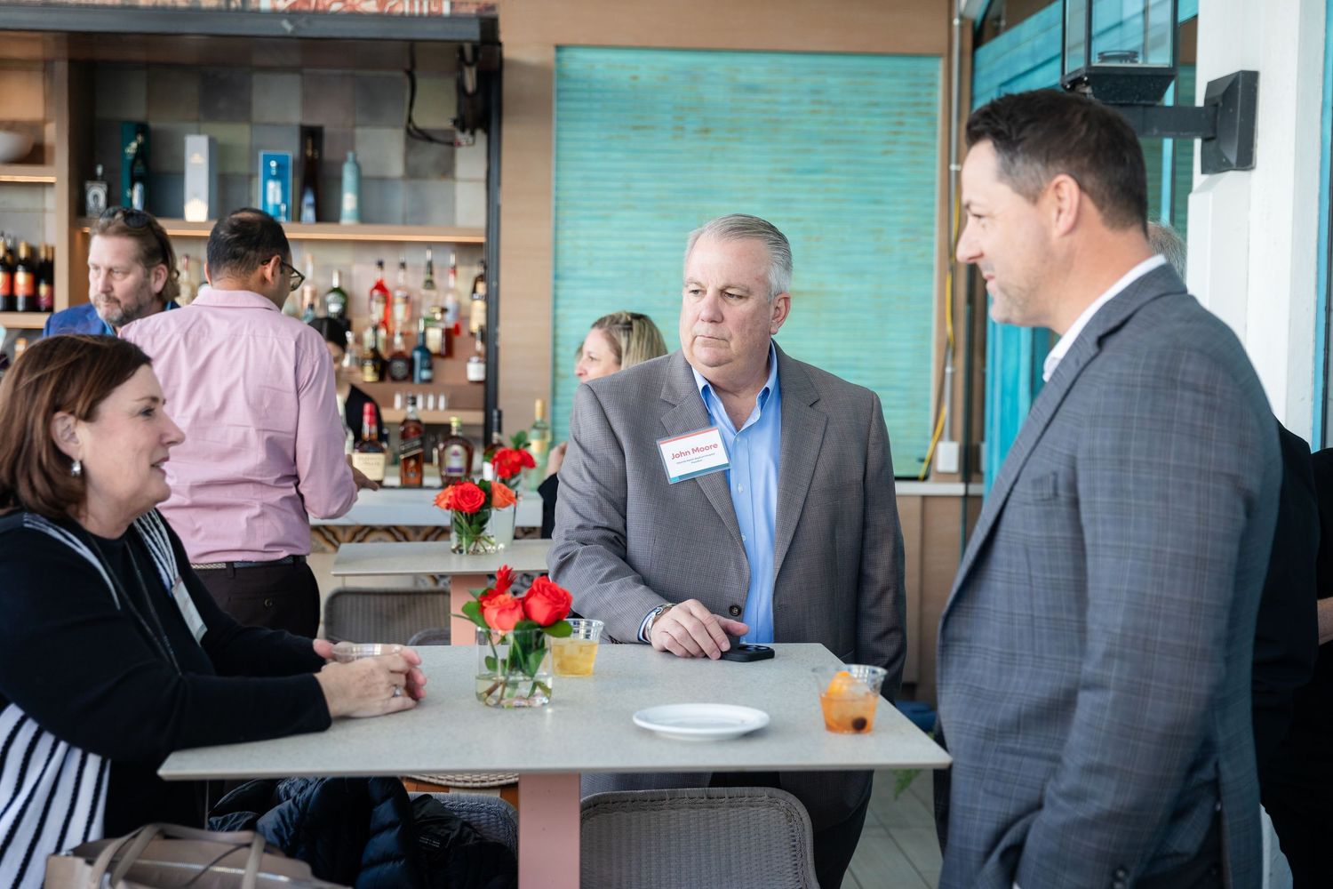 Business professionals having a conversation at a table during a corporate networking event.