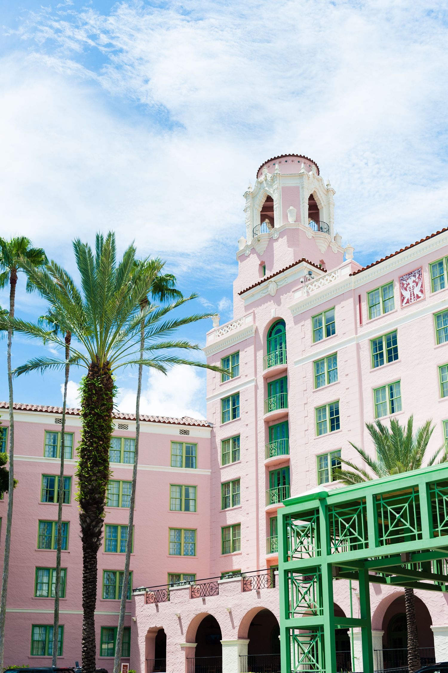 Pink Mediterranean-style hotel with palm trees and blue sky in St. Petersburg, Florida.