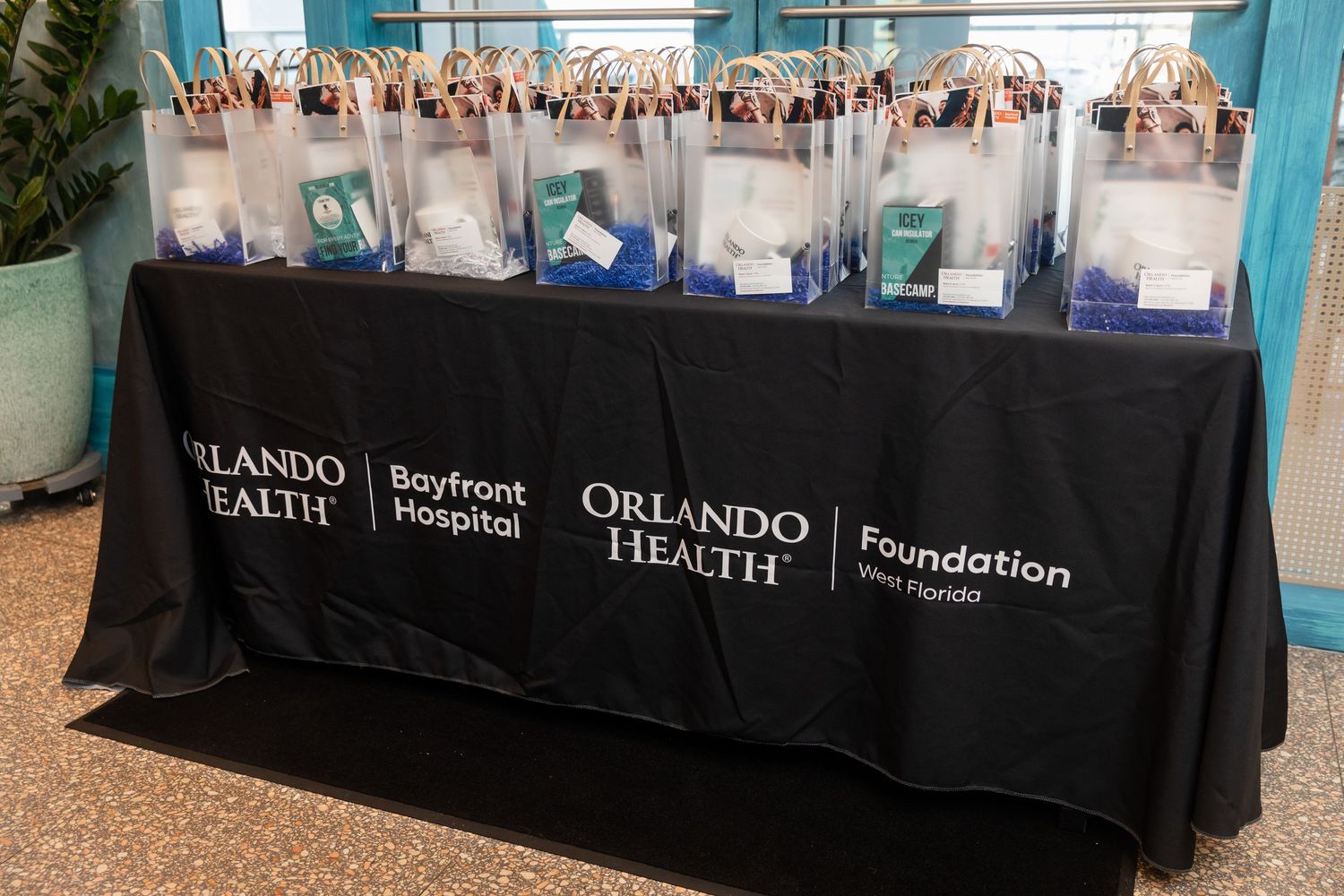 Orlando Health Bayfront Hospital Foundation table display with branded gift bags at a healthcare event.