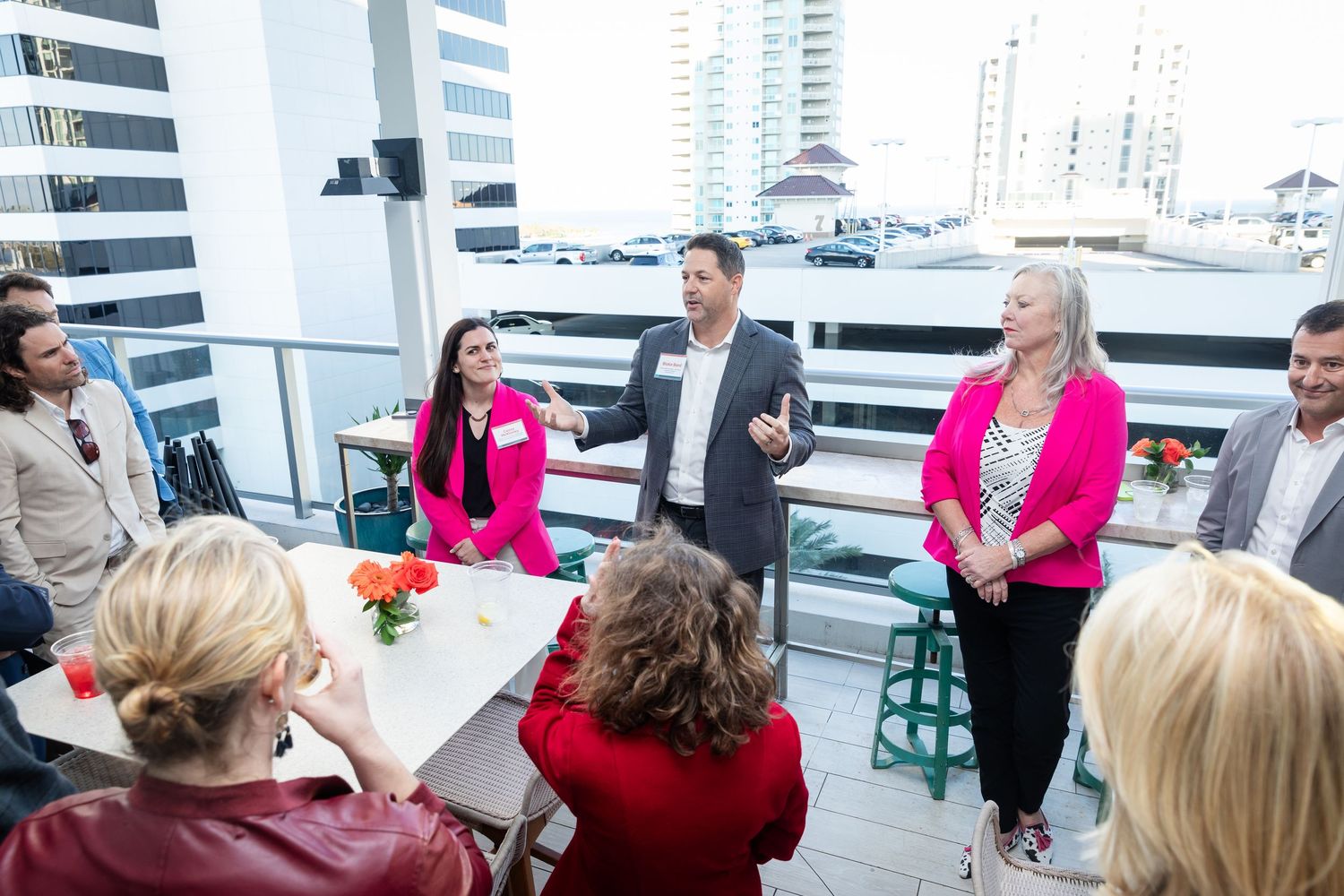 Business professionals gathered on a rooftop terrace for a corporate networking event.