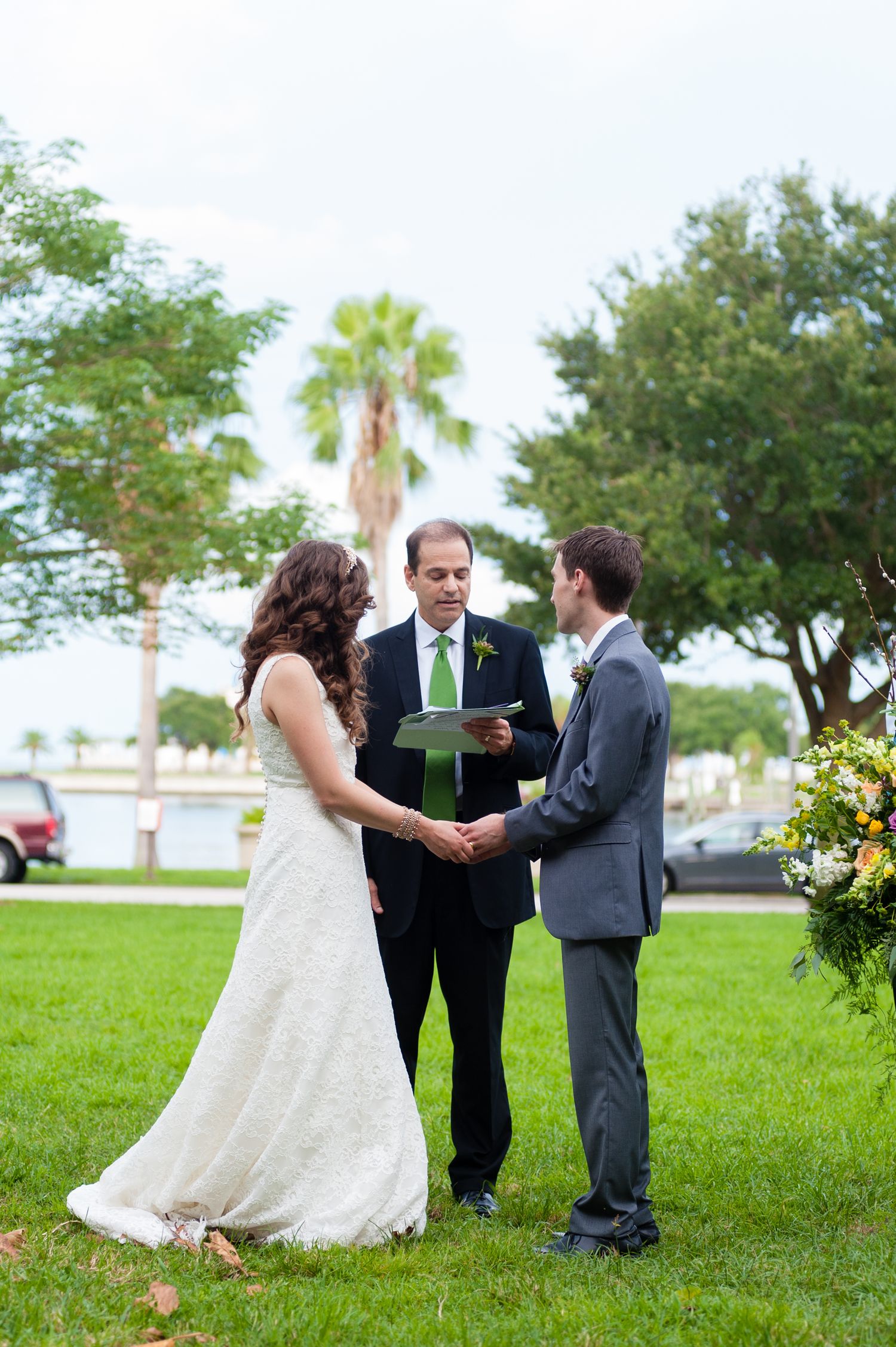 Bride and groom exchanging vows outdoors with officiant during an intimate garden wedding ceremony.