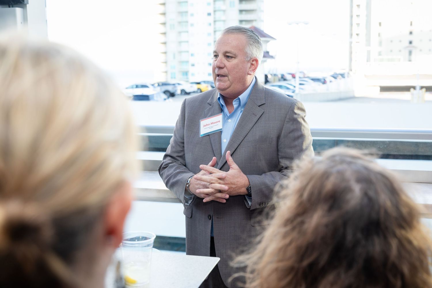 Male speaker in gray blazer presenting to an audience at an Orlando Health professional gathering.