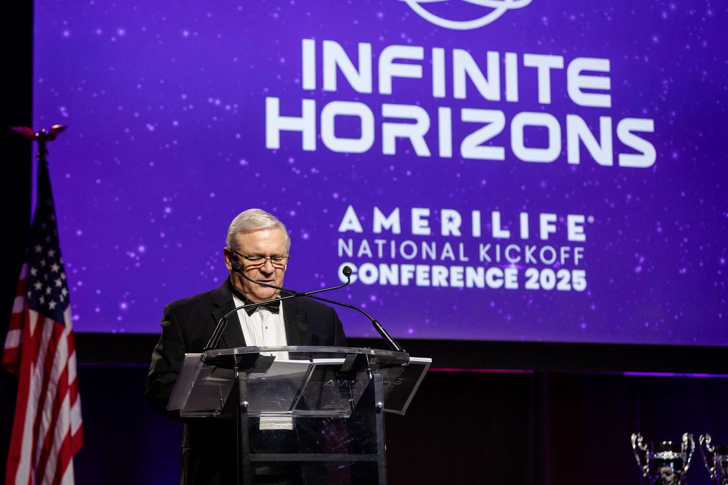 Executive speaks at AmeriLife National Kickoff Conference 2025 Infinite Horizons event on stage with purple backdrop.