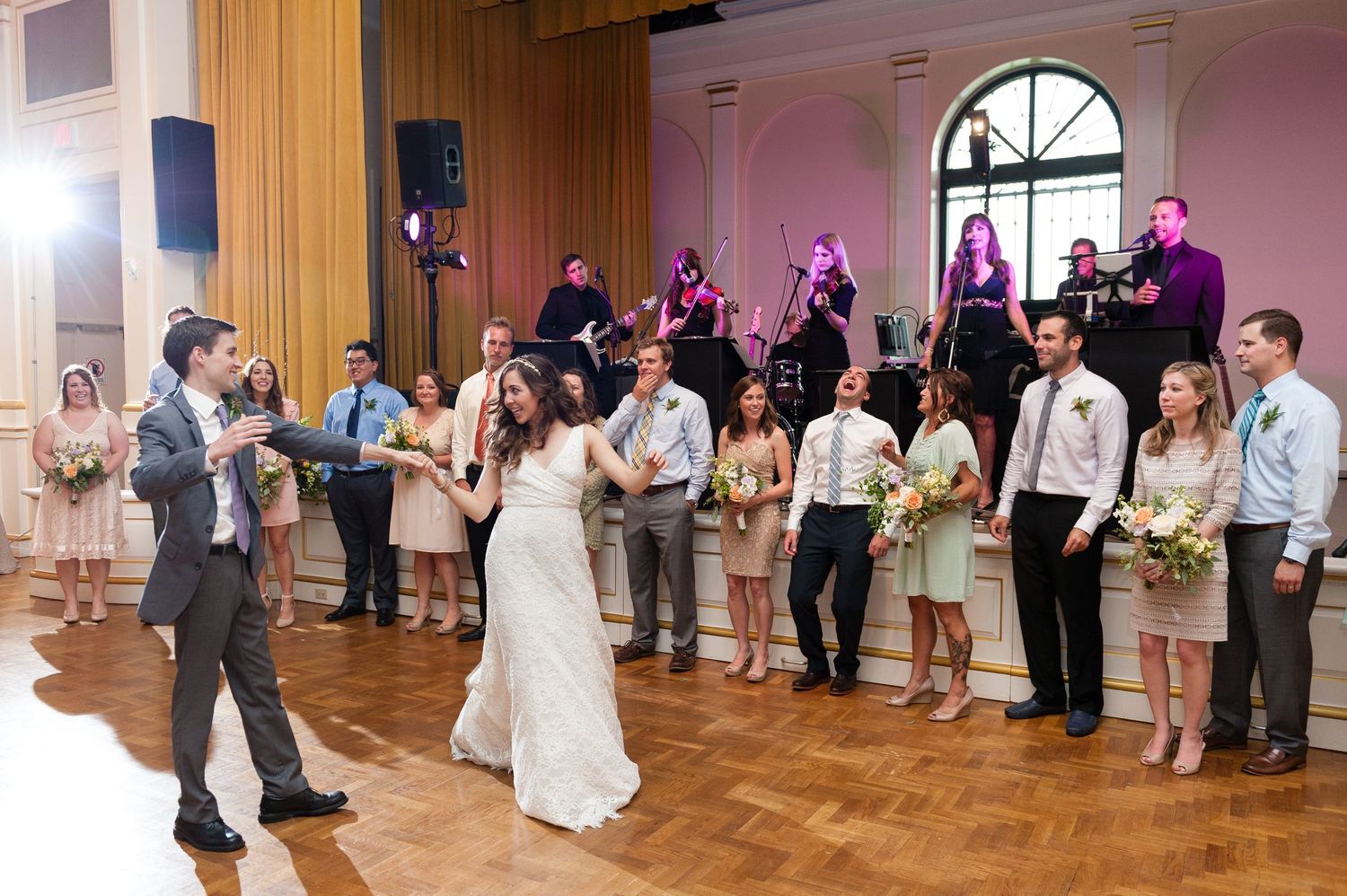 Wedding party joins bride and groom on dance floor during lively reception celebration with live band Museum of Fine Arts, St. Petersburg.