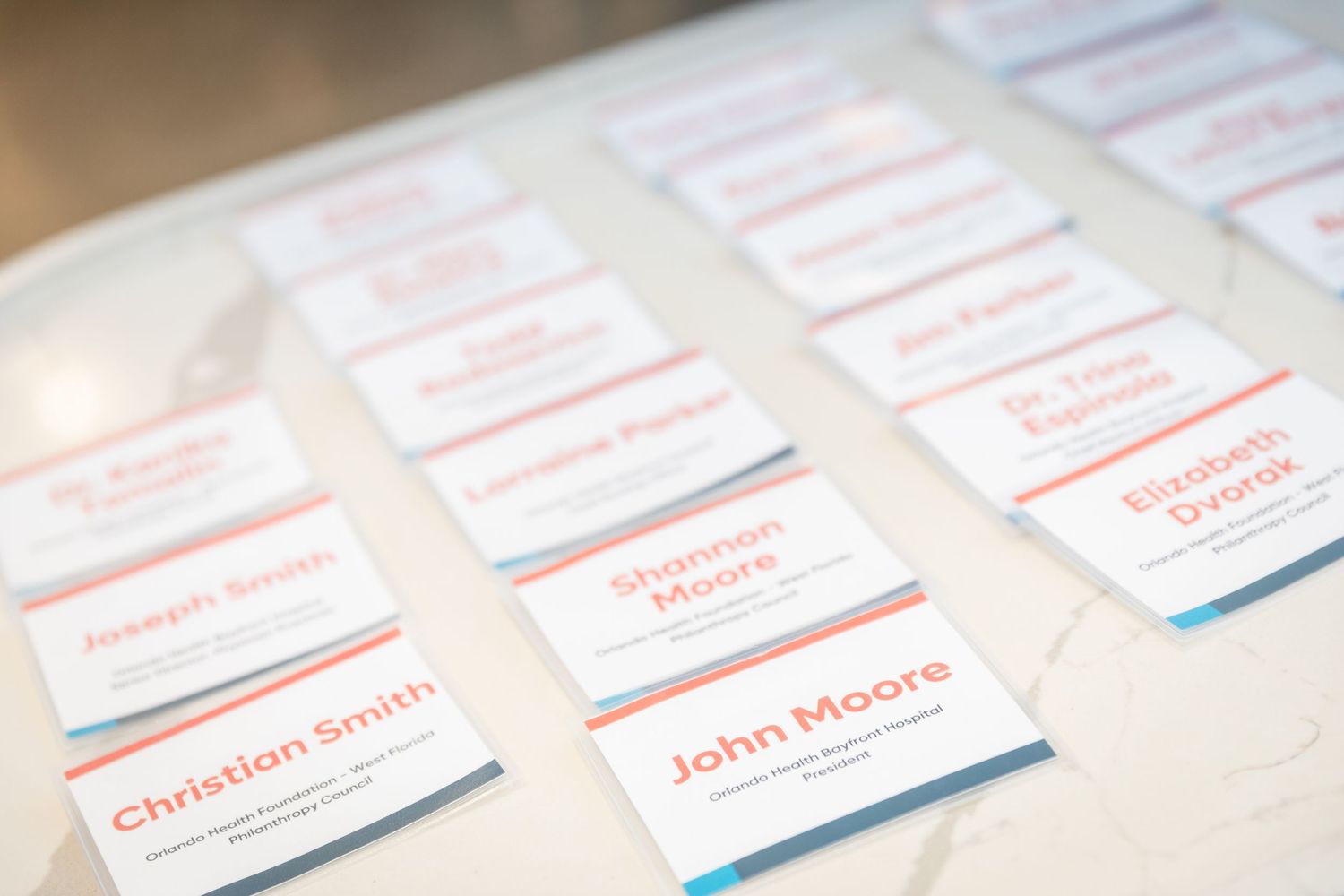Name cards arranged on a white table at a formal event, including John Moore and Christian Smith.