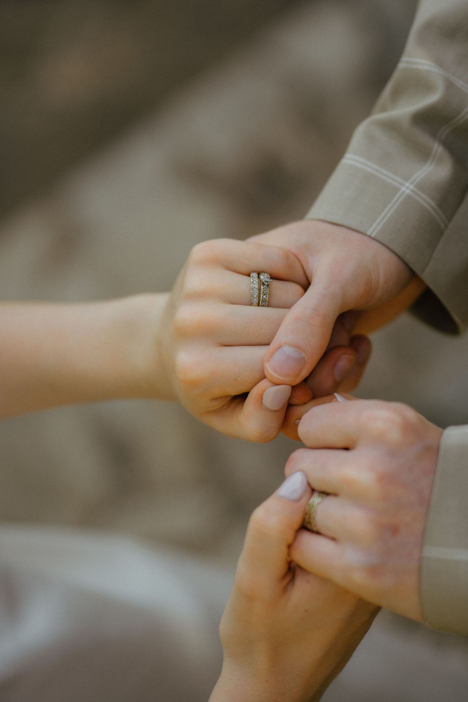 Close-up of newlyweds holding hands showing wedding rings after ceremony.
