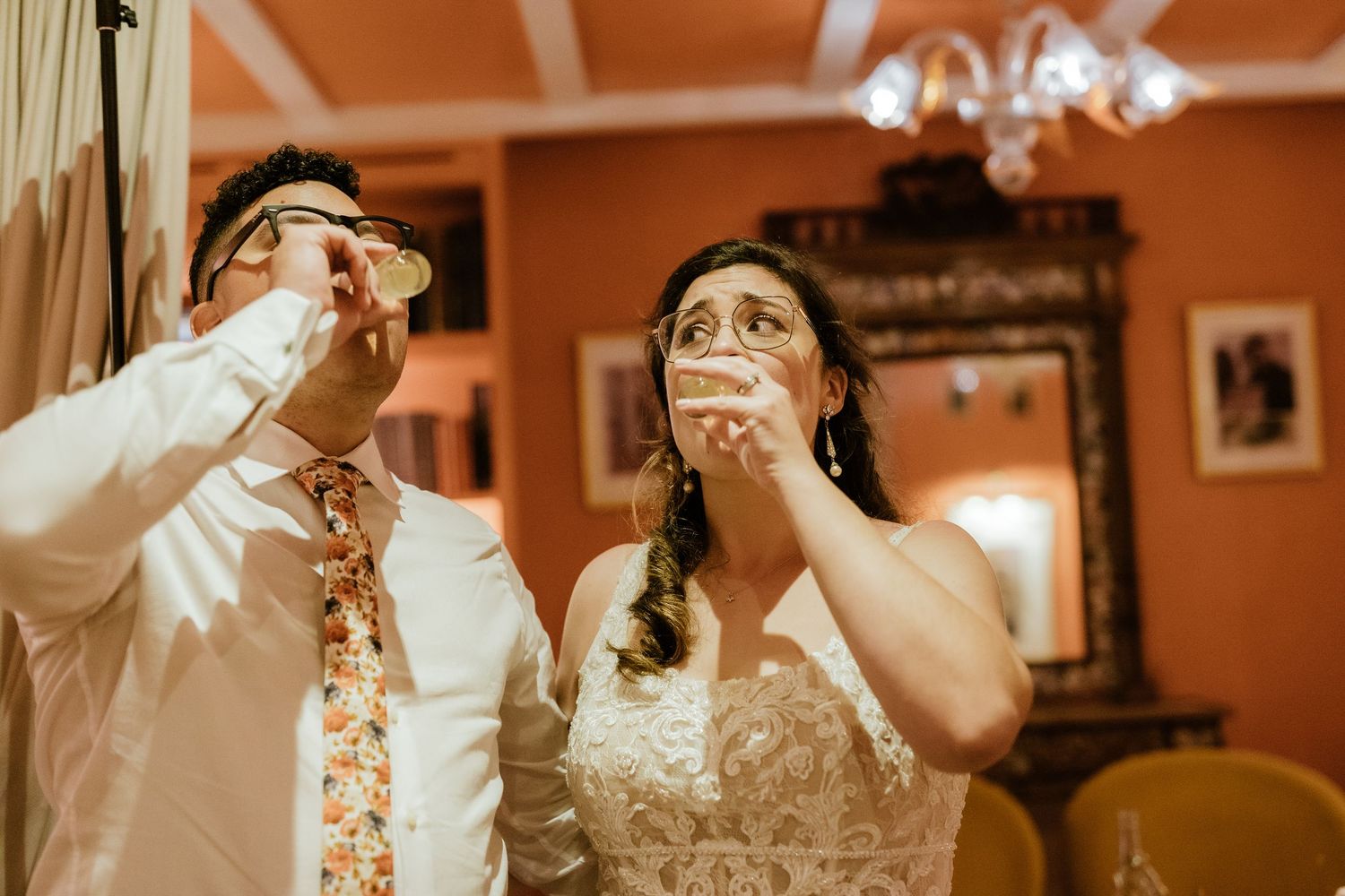 Bride and groom taking shots together during their wedding reception celebration.