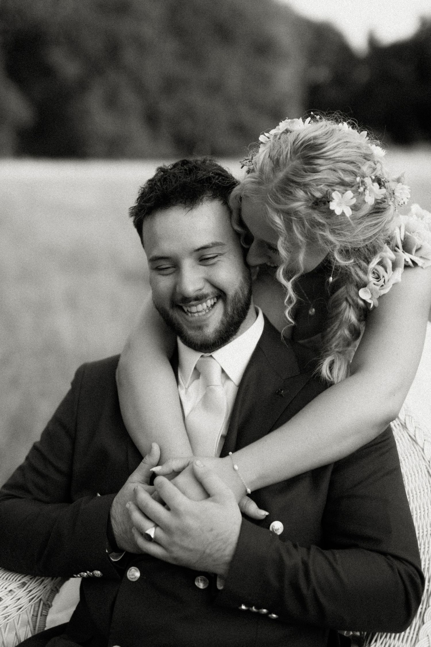 Black and white romantic wedding portrait of a joyful moment shared between newlyweds.