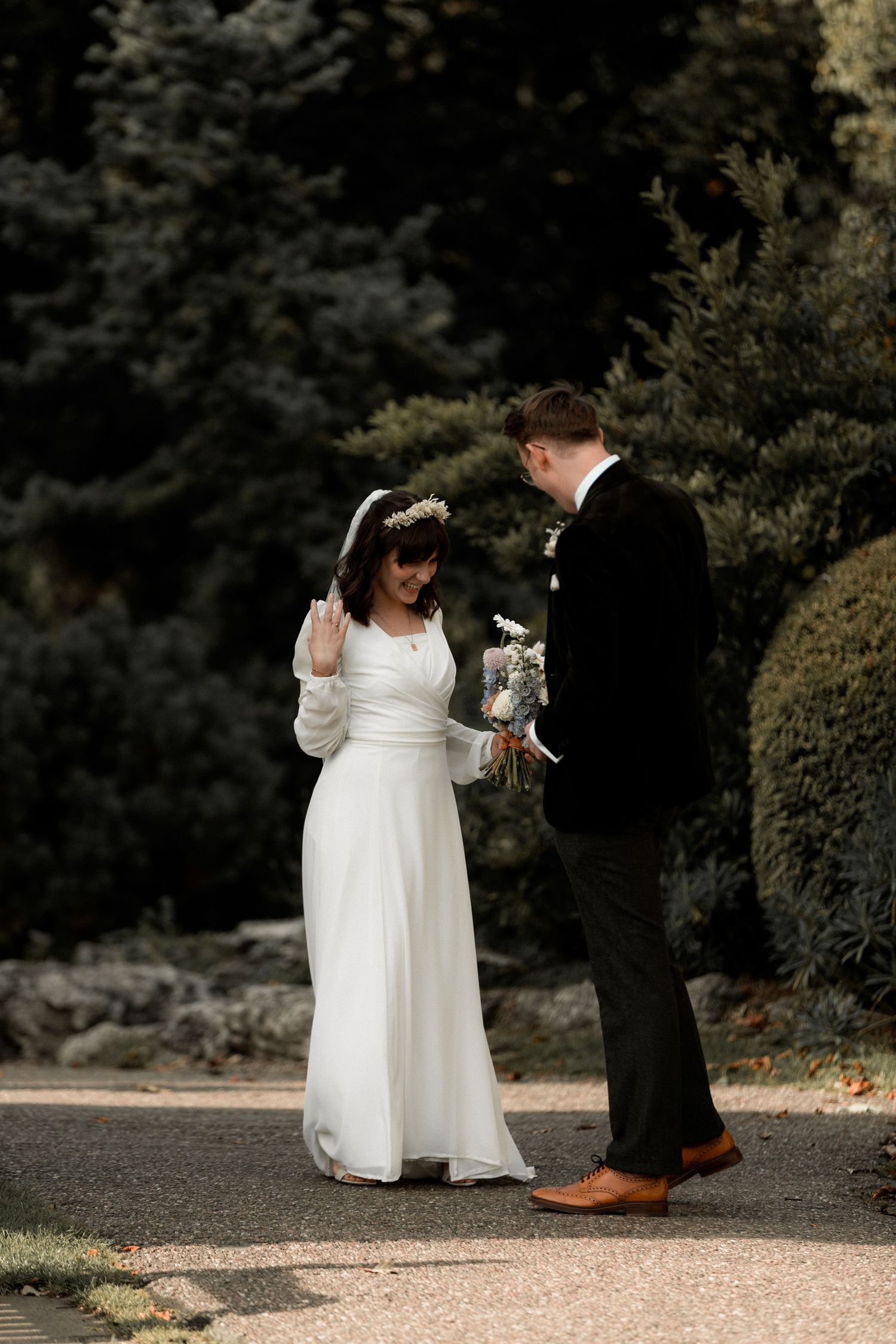 A couple sharing a moment on a garden path during their wedding day.