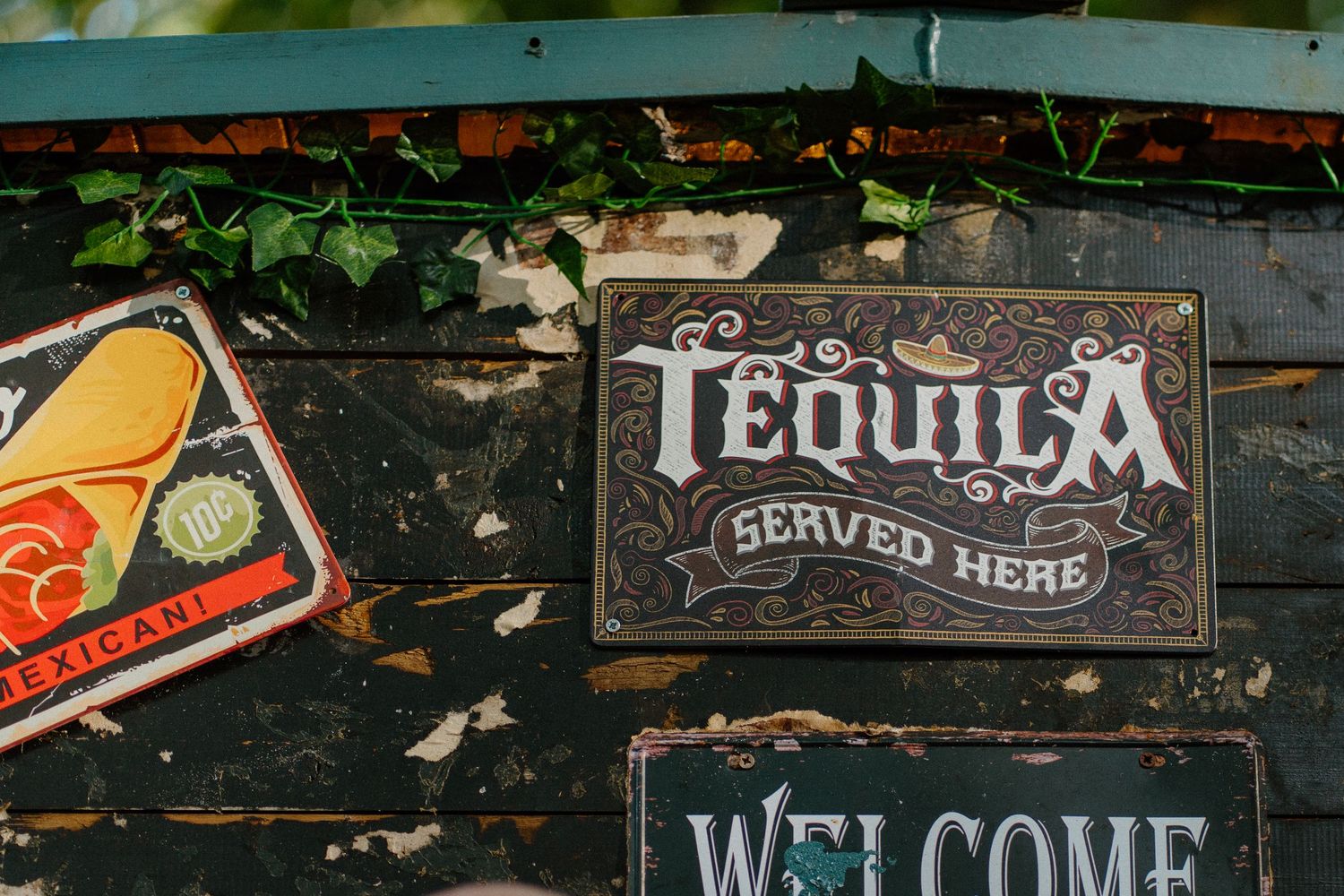 Vintage style tequila sign and decorative elements on rustic wall.