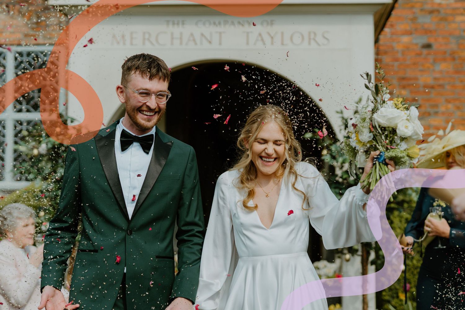 Happy couple celebrating with confetti outside Merchant Taylors Hall, groom in emerald green tuxedo, bride holding bouquet.