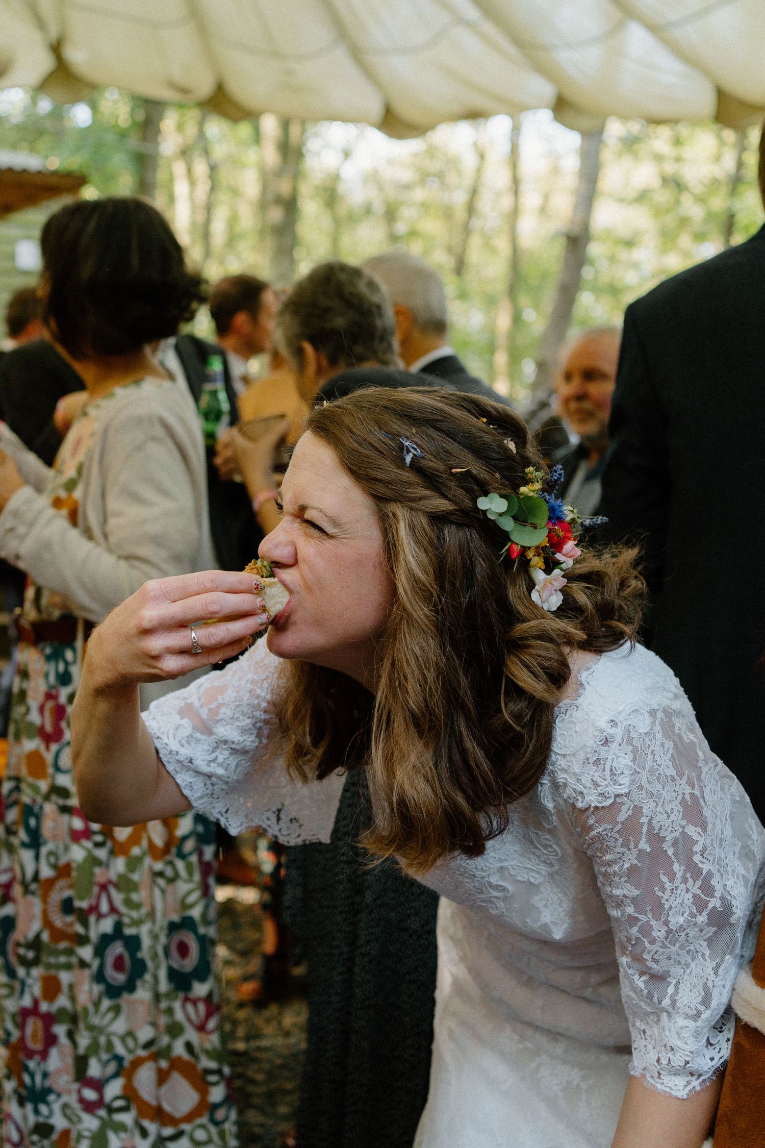 Guests raise their glasses and take celebratory shots together during an outdoor wedding reception.