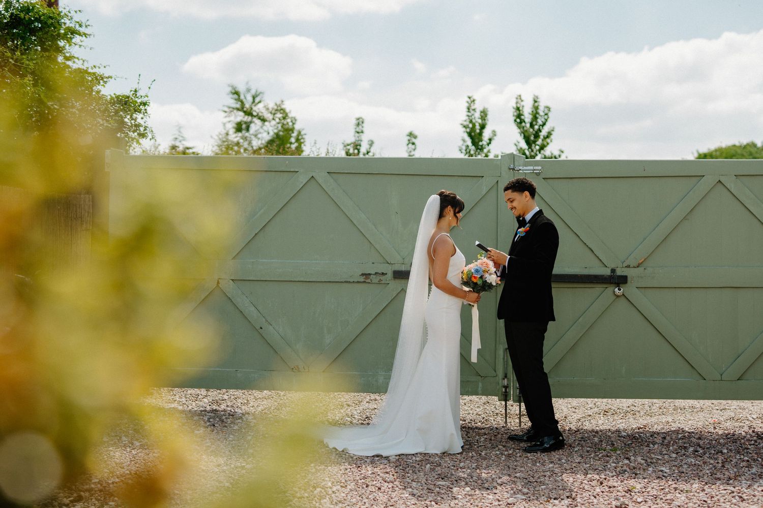 Bride and groom share a tender first look moment before their wedding ceremony outdoors.