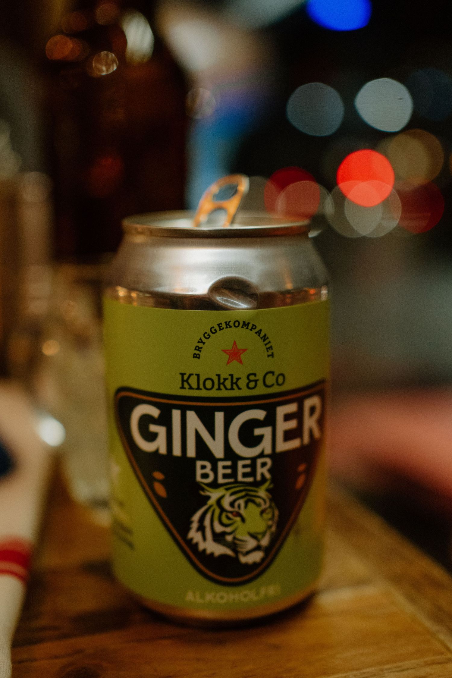 Close-up shot of a Klokk & Co ginger beer can with bokeh lights in the background.