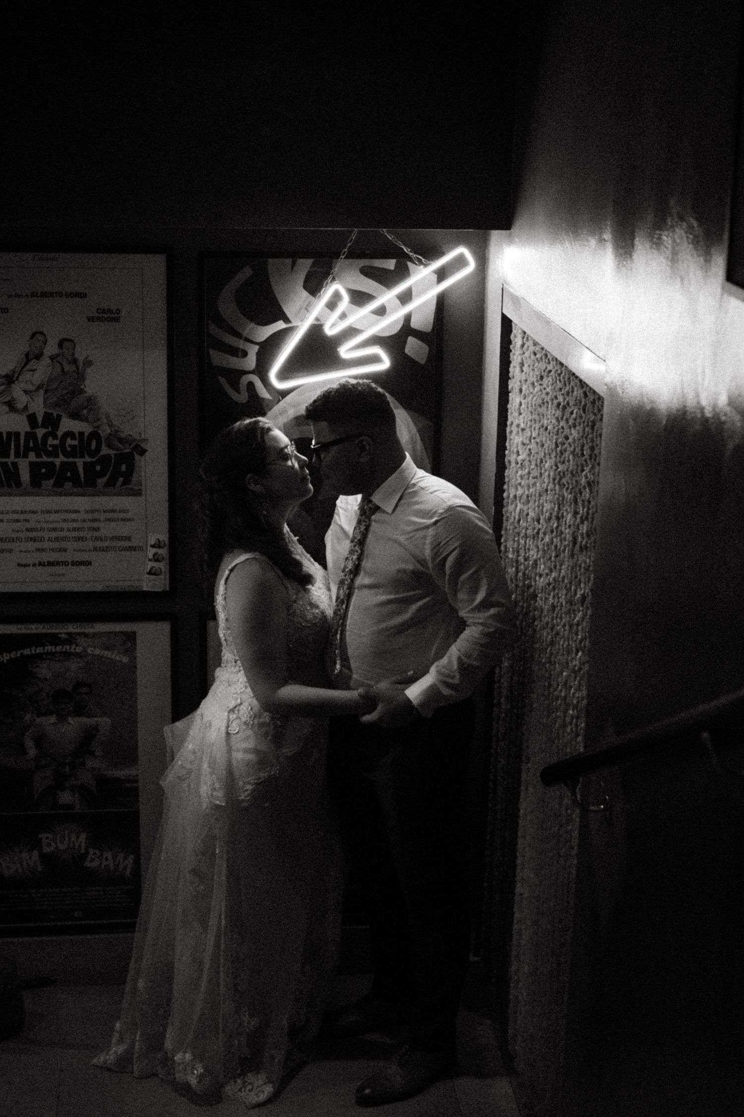 Bride and groom sharing a romantic kiss in a black and white night photo.
