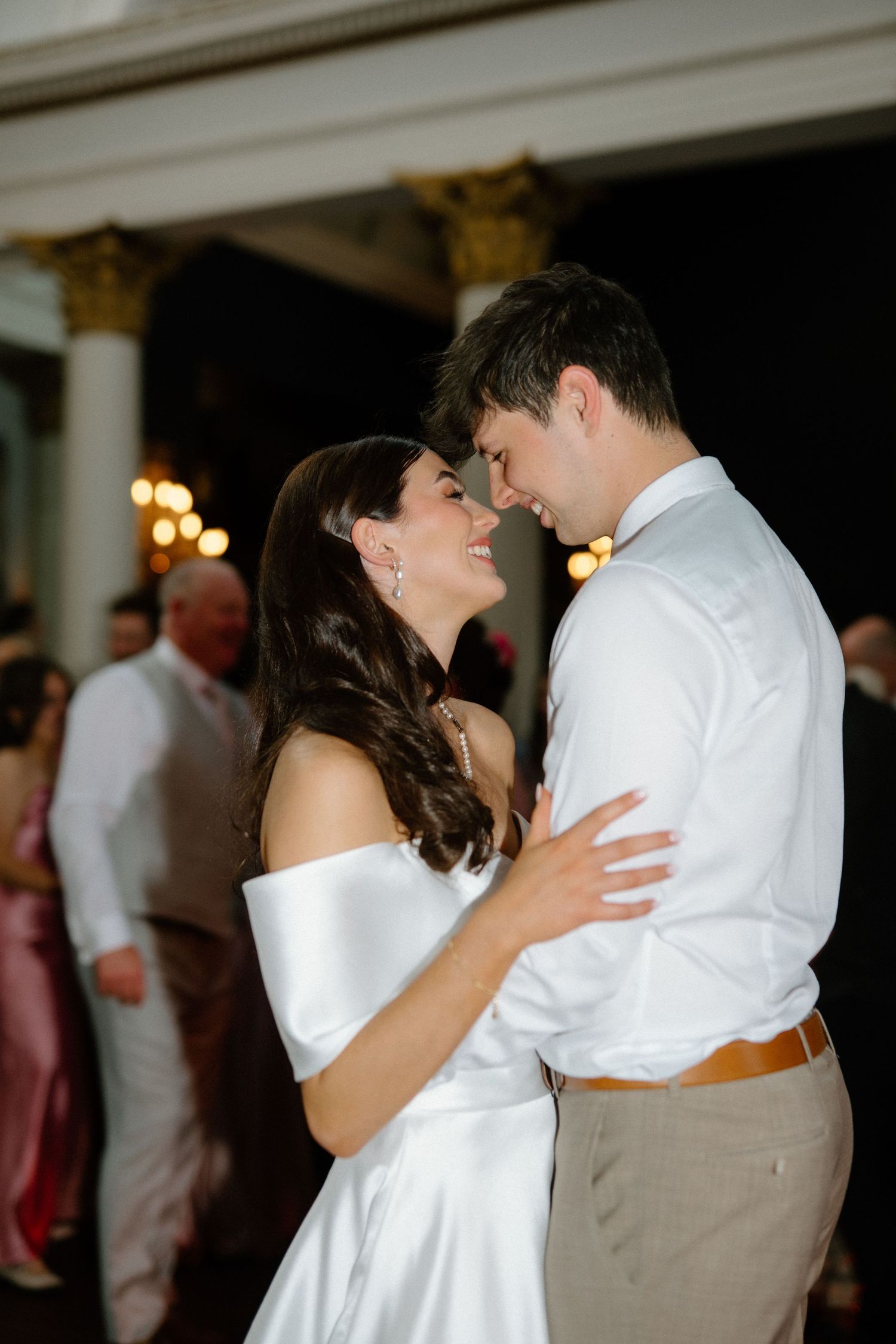 Bride and groom sharing an intimate first dance moment, smiling at each other at wedding reception.