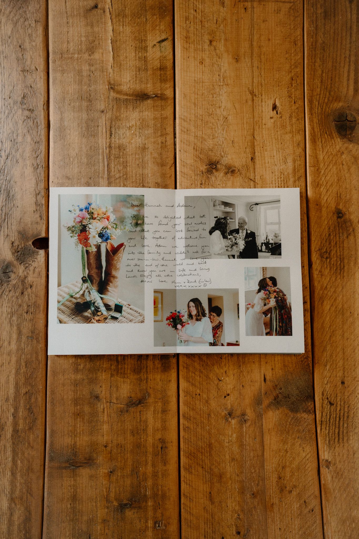 A collection of vintage photographs and handwritten notes displayed on rustic wooden floorboards.