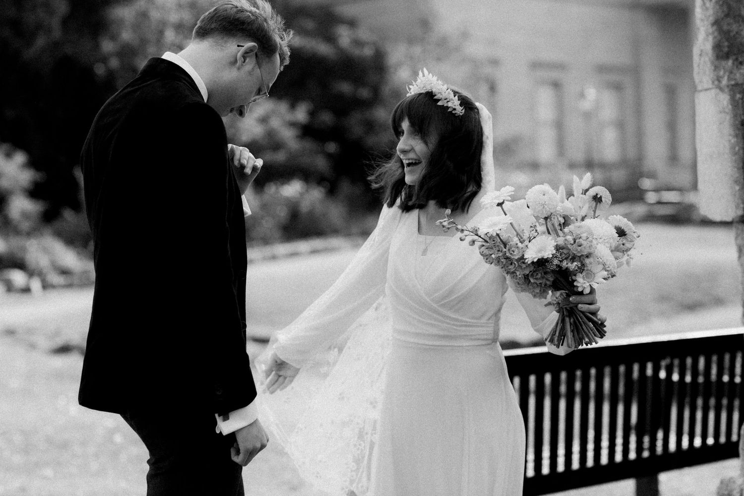 A romantic black and white wedding photo of a couple sharing a special moment outdoors.