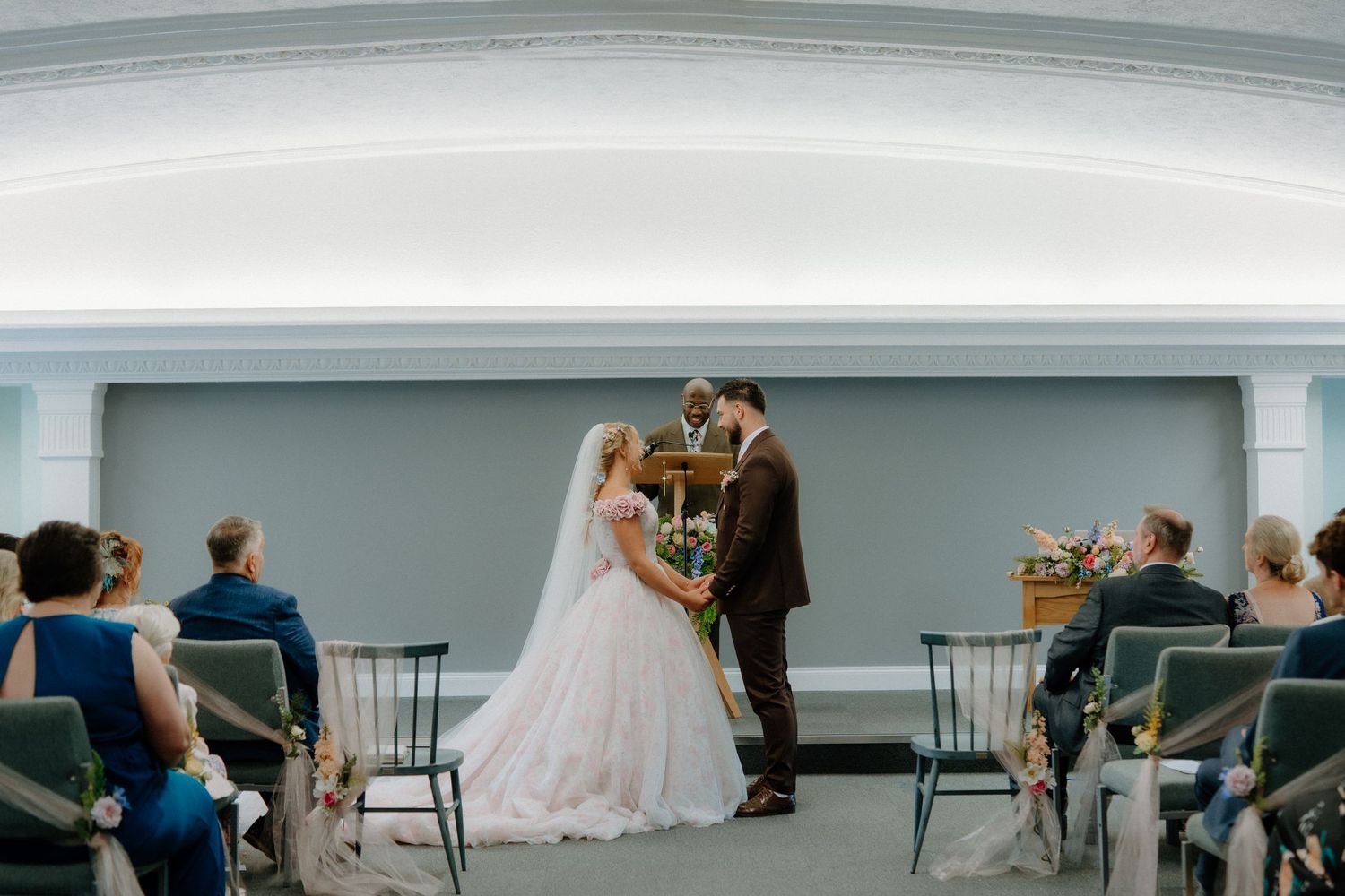 Bride and groom stand at the altar during an intimate wedding ceremony in an elegant venue.