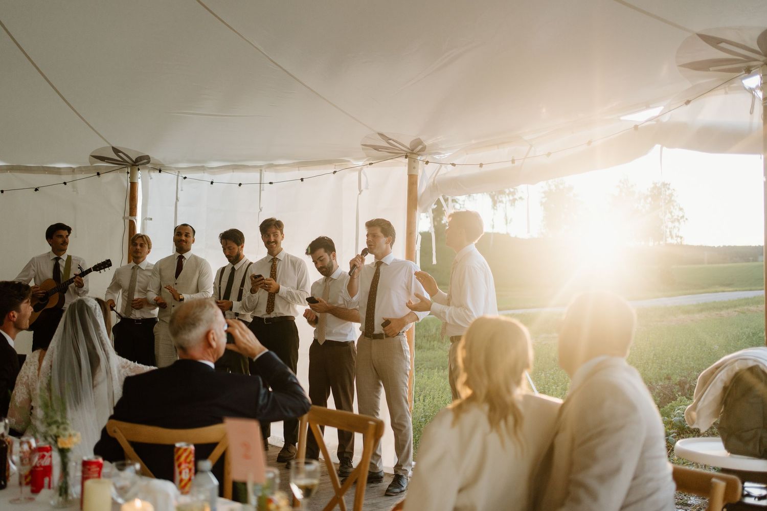 Groomsmen performing a musical serenade for bride and groom at golden hour reception.