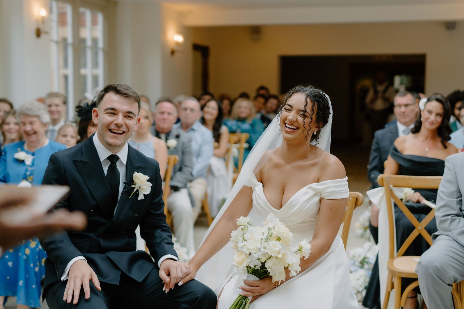Bride and groom laugh joyfully together during their wedding ceremony.