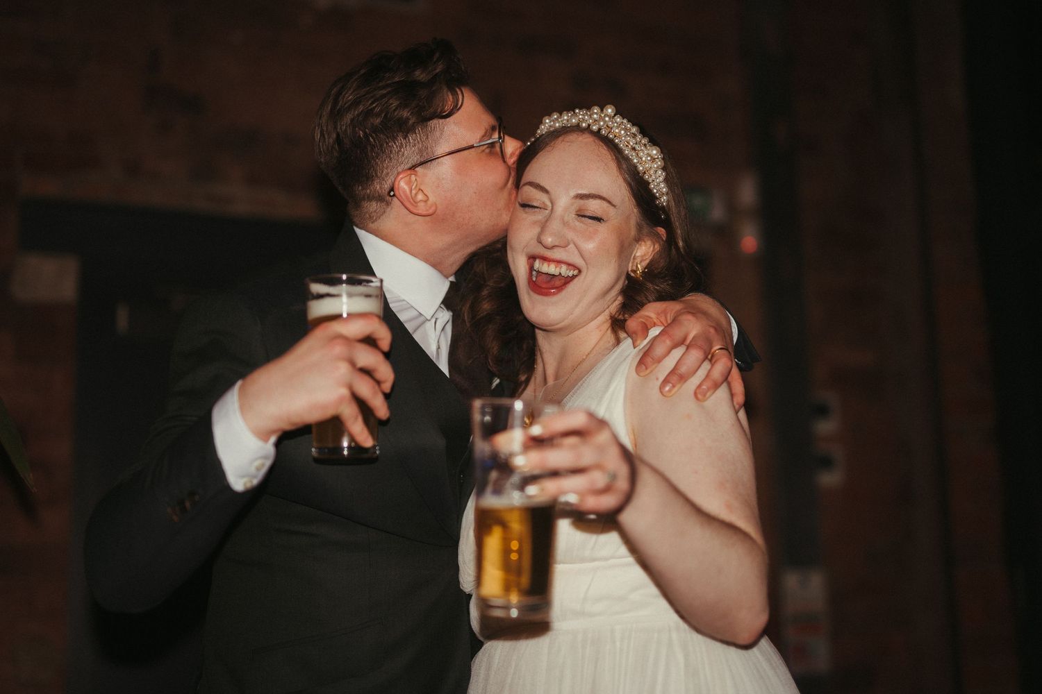 A joyful wedding celebration moment with drinks being shared. Brewery Wedding in Leeds.