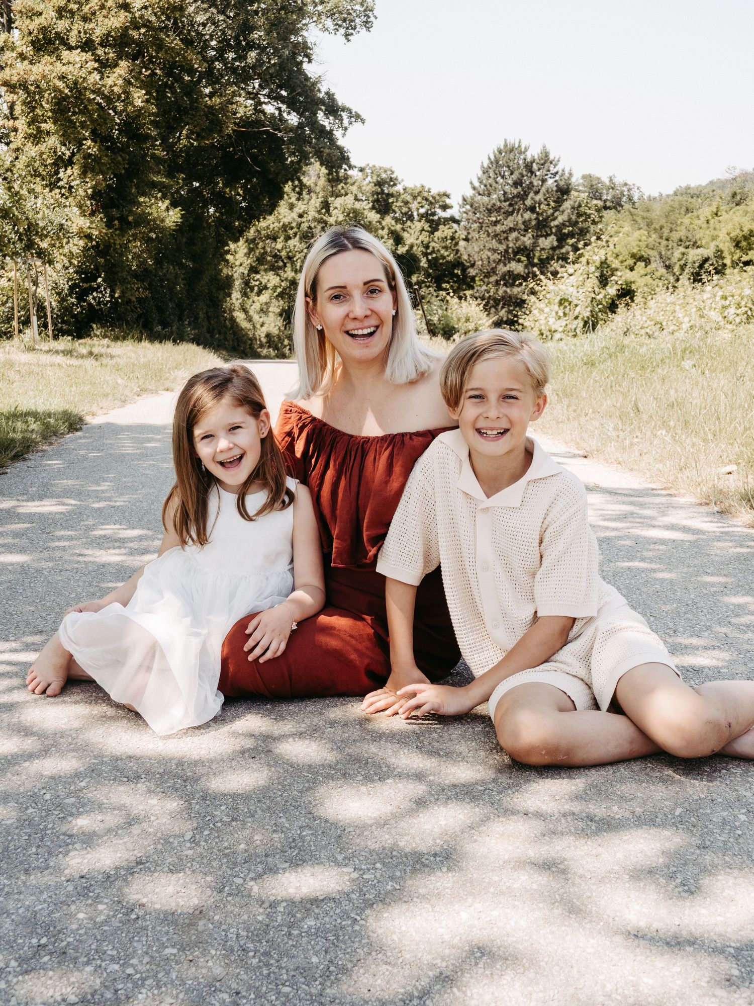 Candid outdoor summer photoshoot capturing joyful moments on a sunlit path.