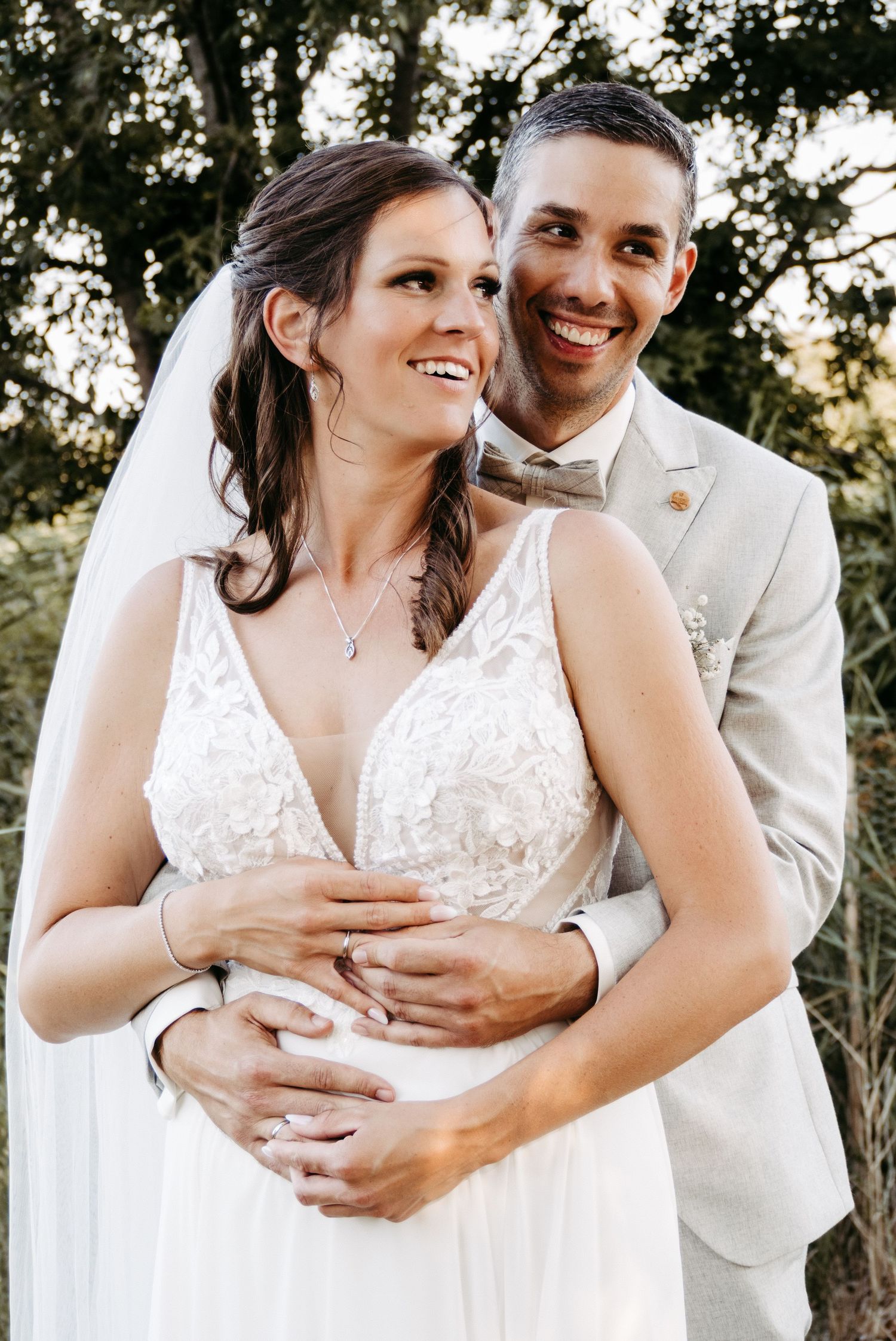 Wedding couple sharing intimate moments in white attire against natural backdrop.