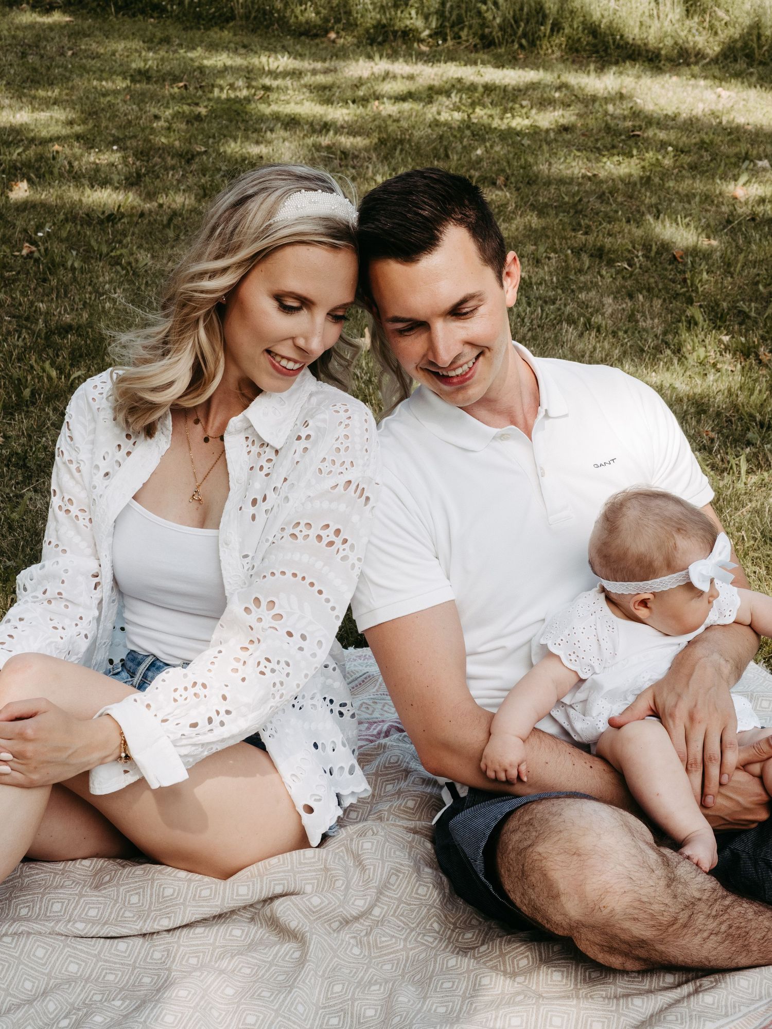 Tender family photography session on a blanket outdoors capturing intimate moments together.