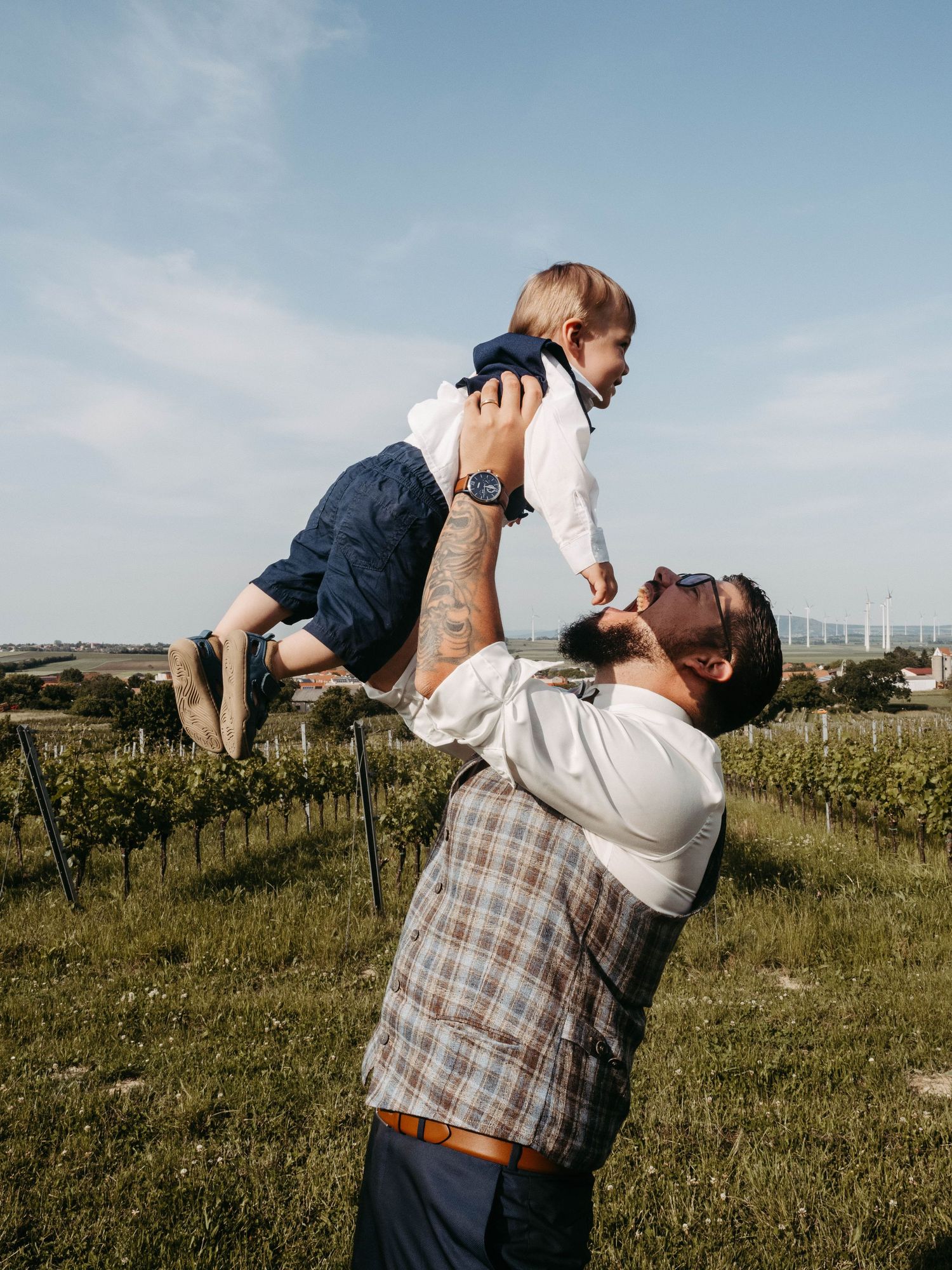 Playful wedding photo sequence in vineyard with groom dipping bride.