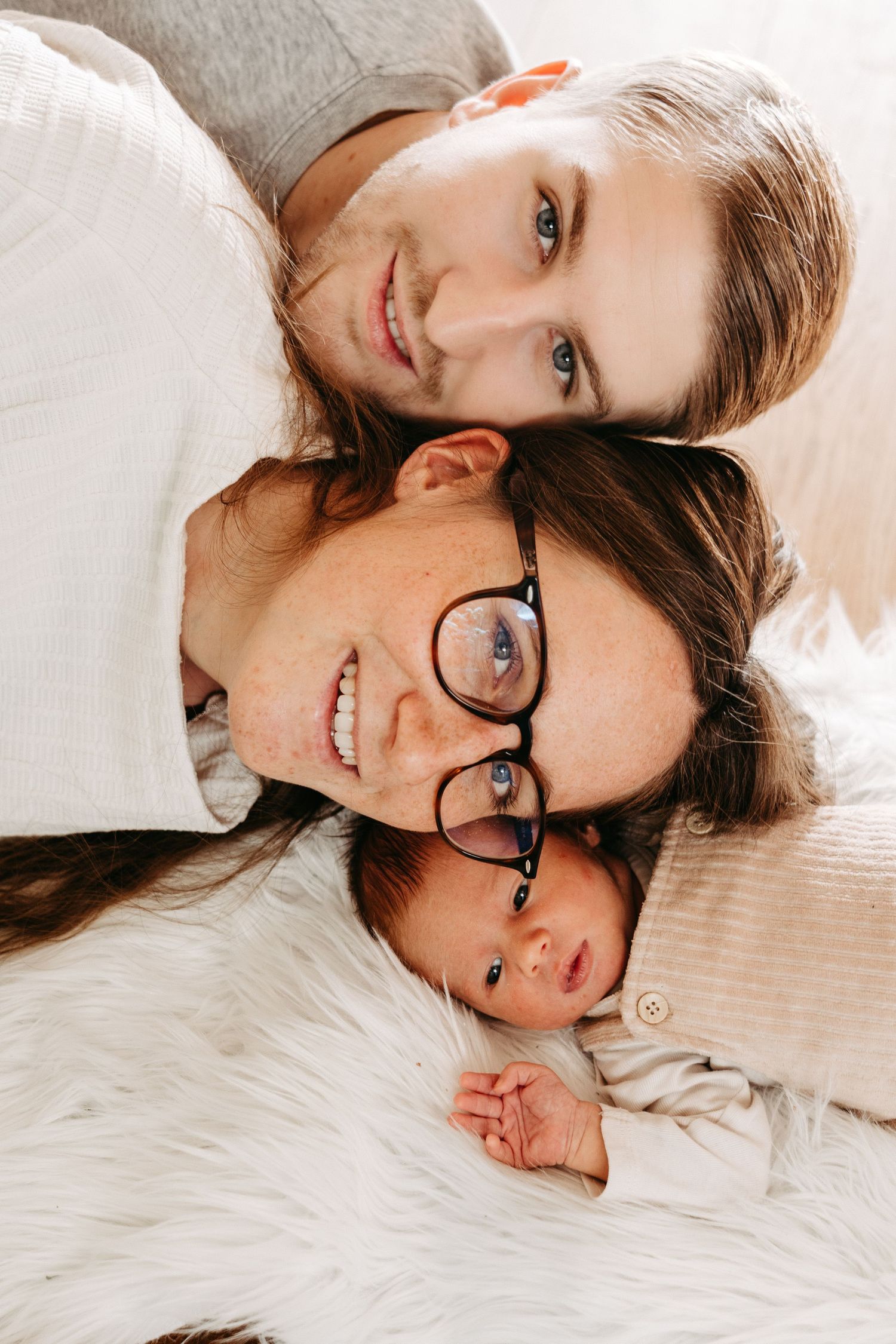Person wearing glasses lying on white bedding while making playful expressions in a series of connected photos.