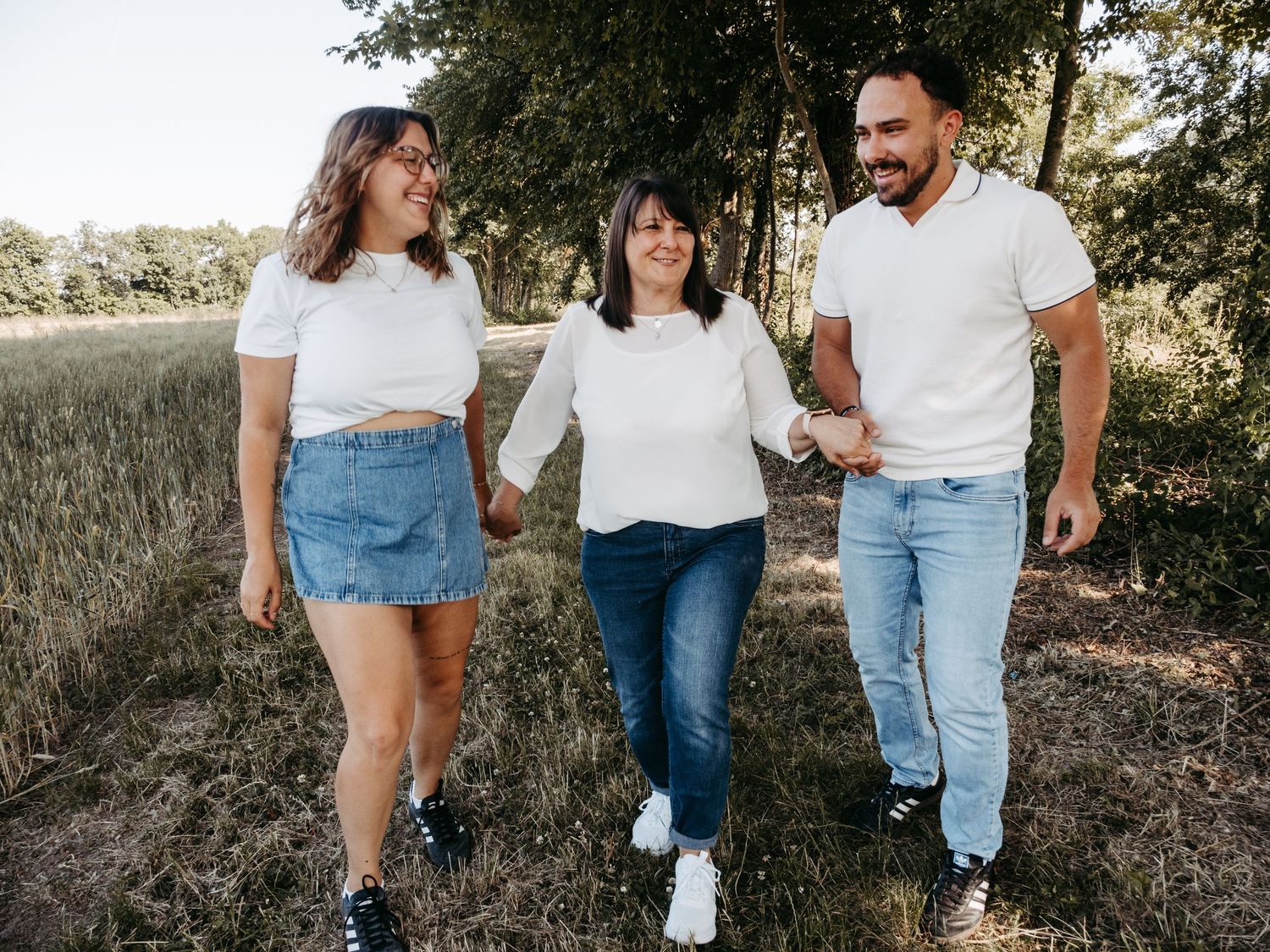 Friends walking together outdoors wearing matching casual white tops and denim.