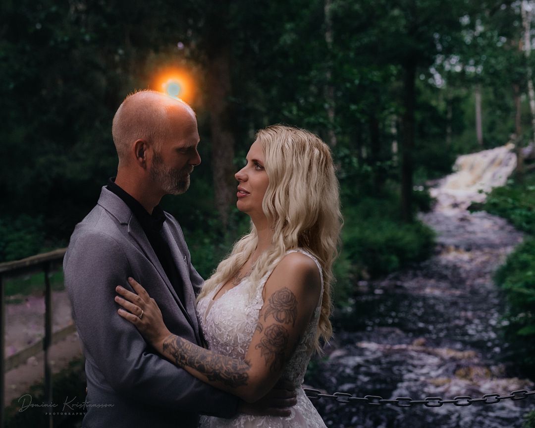 A romantic couple poses in moody forest settings during a series of embracing engagement or wedding photos at dusk.