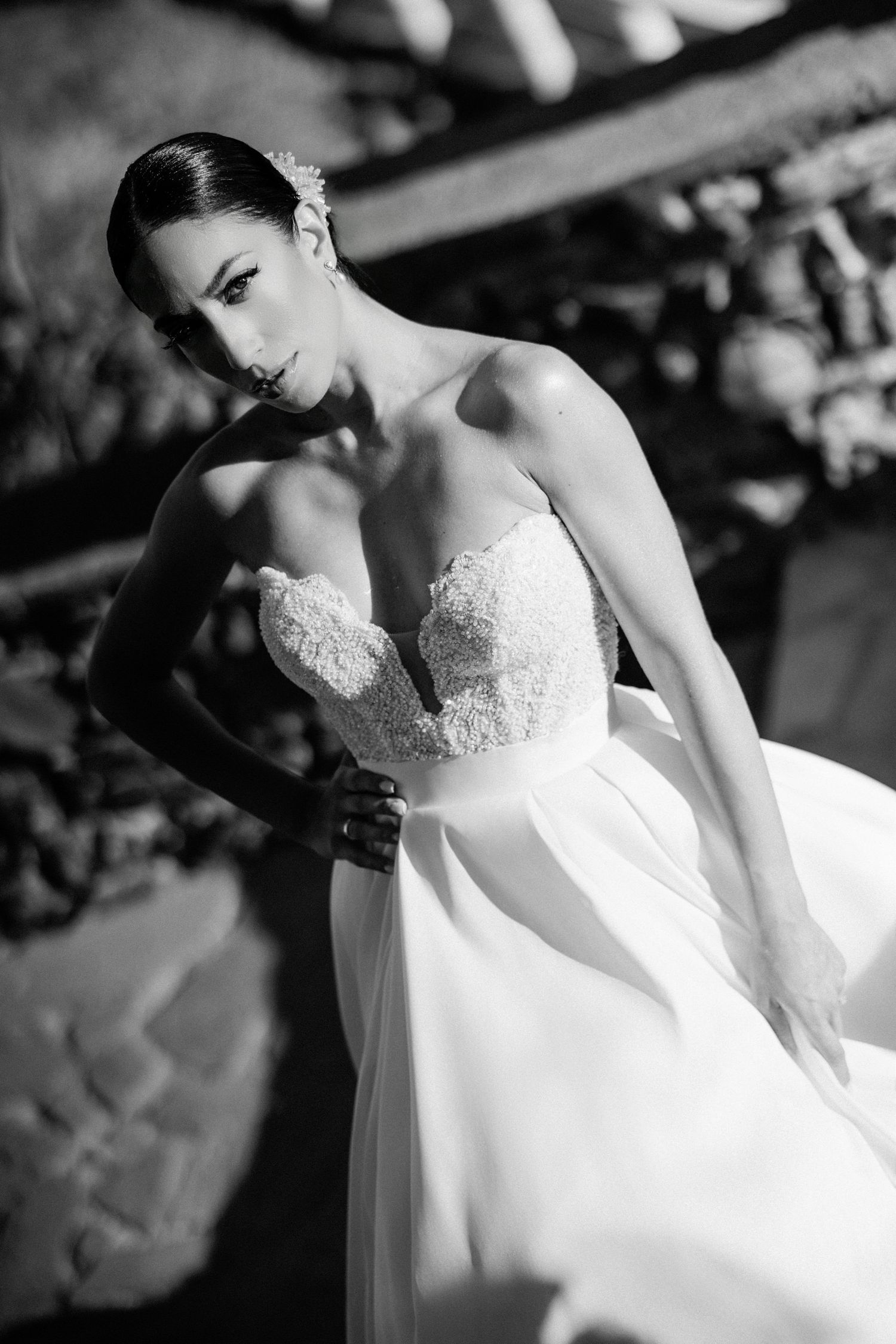 Elegant bride in lace wedding gown shown in dramatic black and white portraits.
