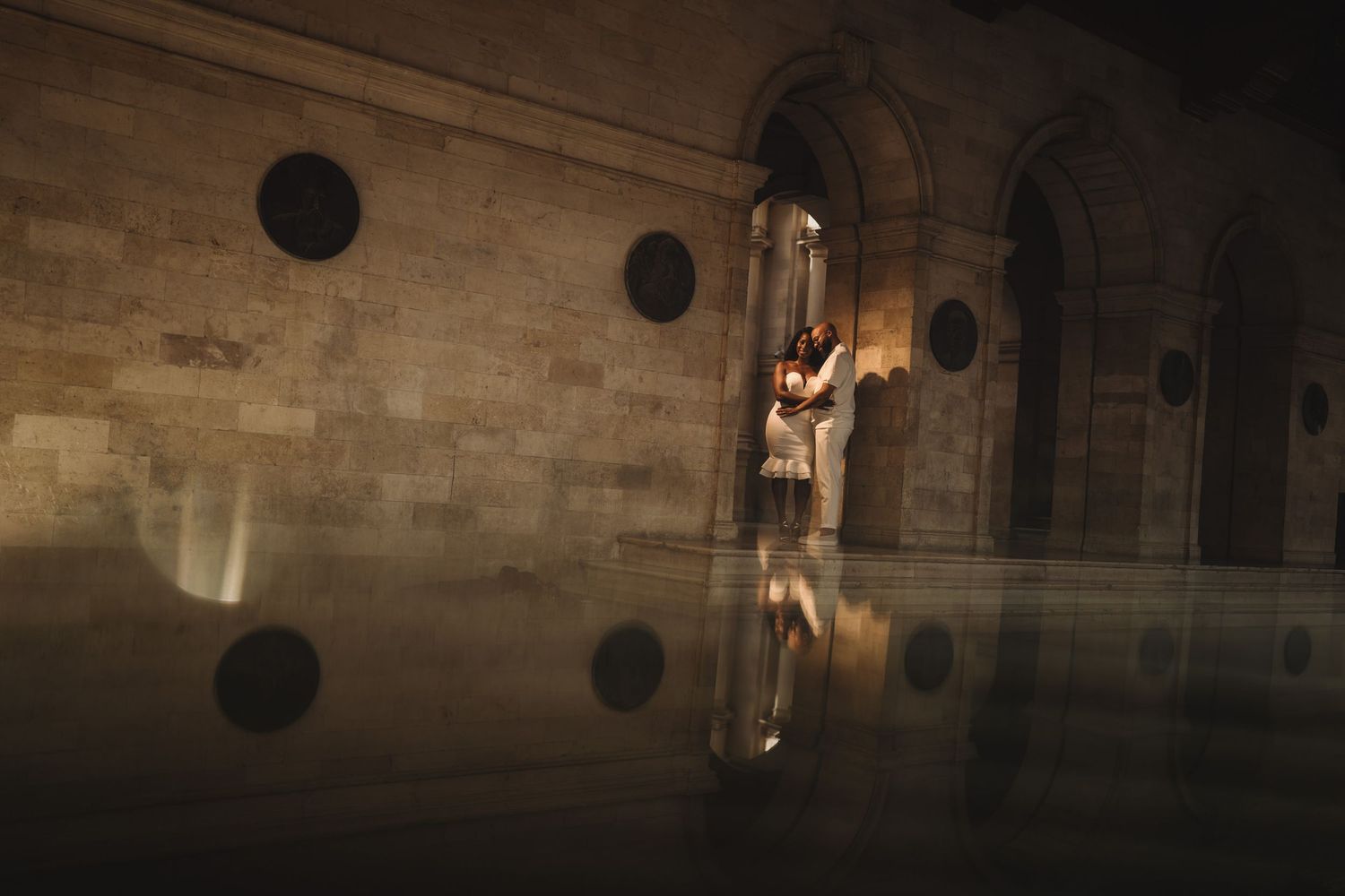 Interior of a historic stone building with dramatic lighting and arched architecture.