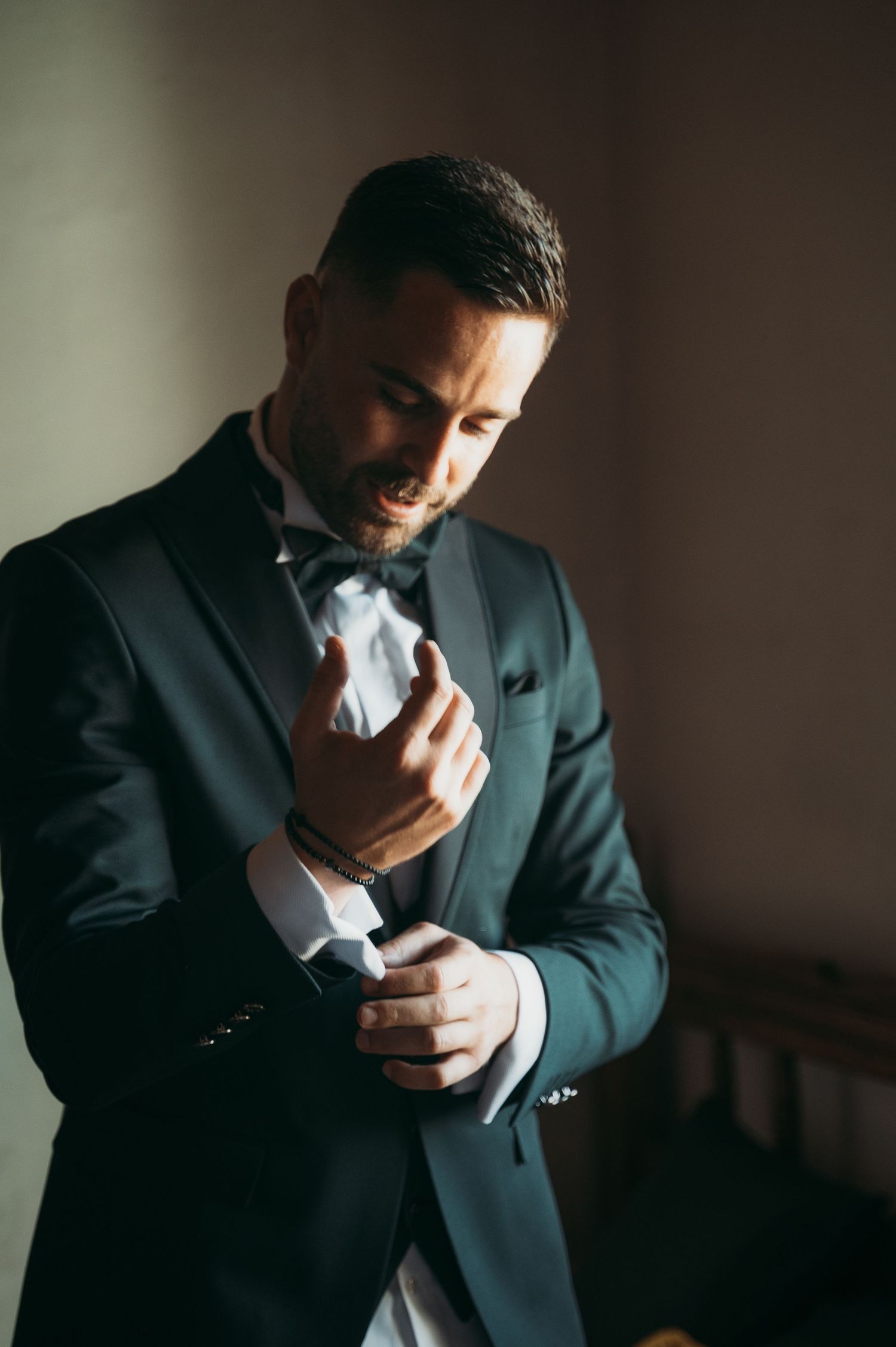 A series of dramatic shots showing a groom in dark suit preparing for his wedding day.