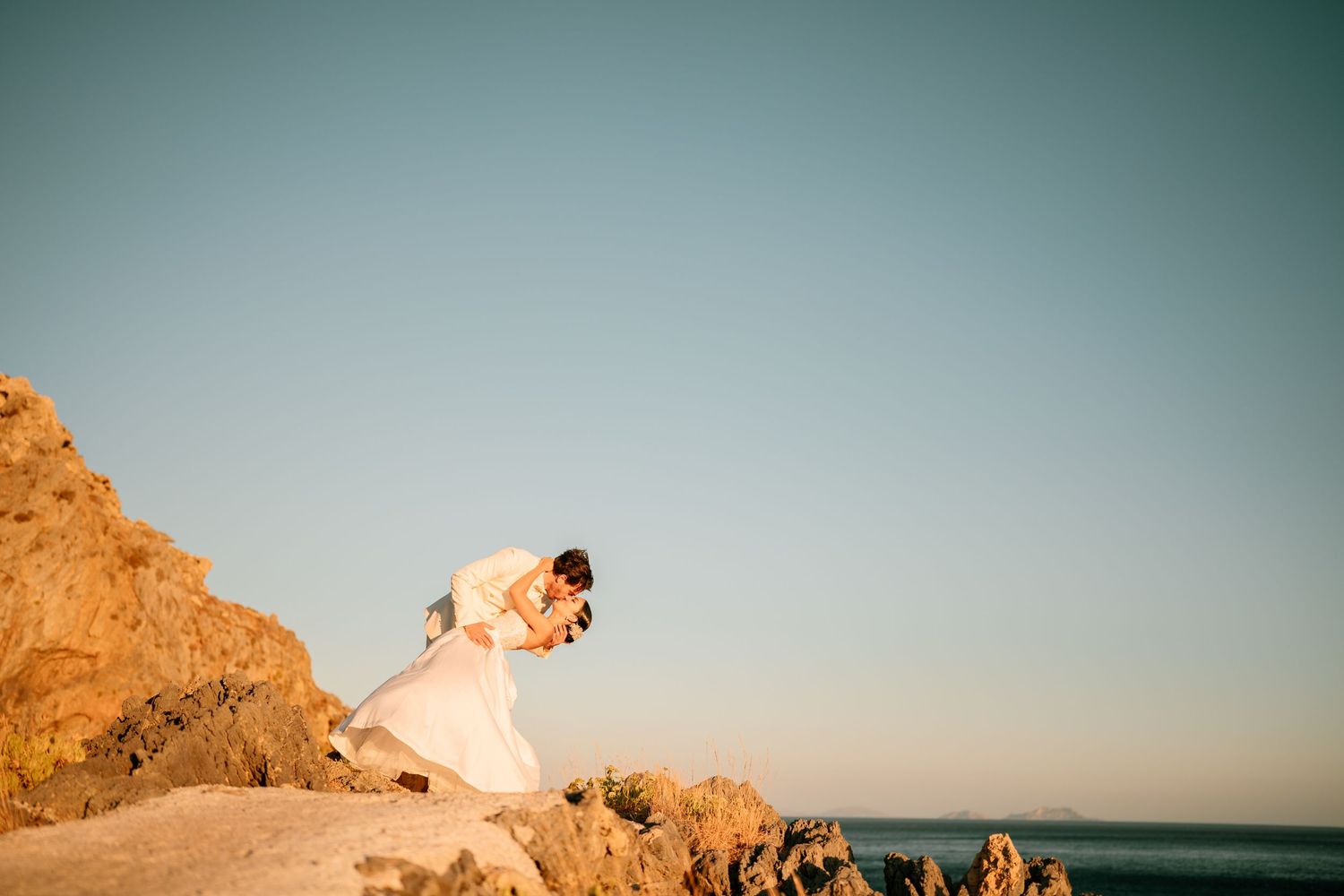 Coastal wedding photography with dramatic cliffs and ocean backdrop.