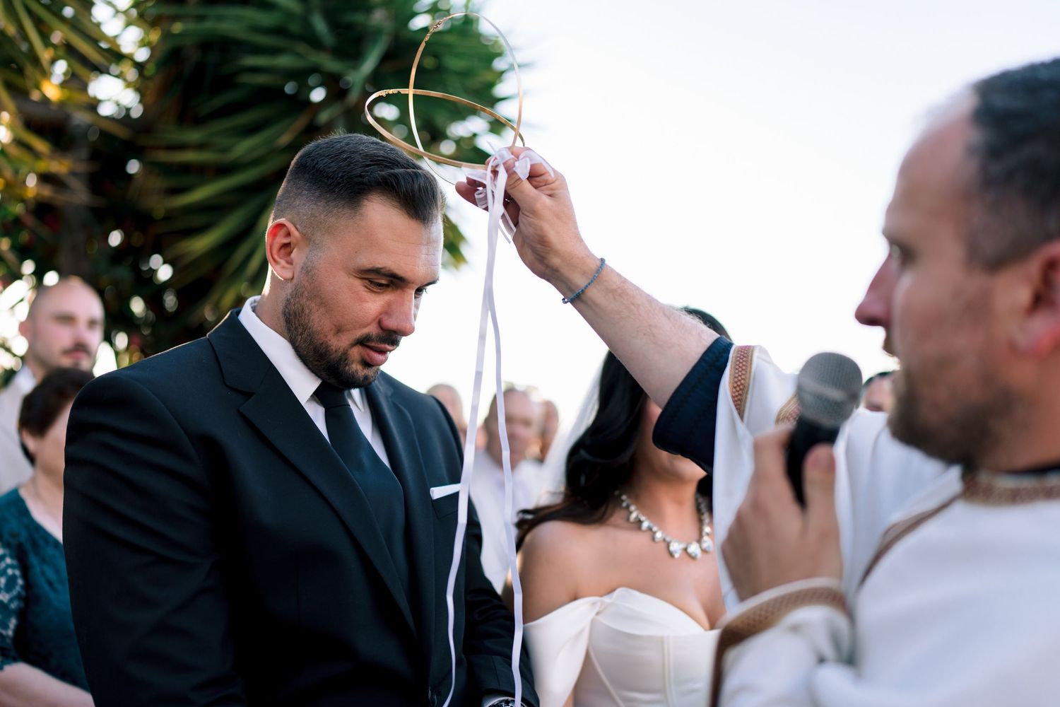 Outdoor wedding ceremony with guests in formal attire.