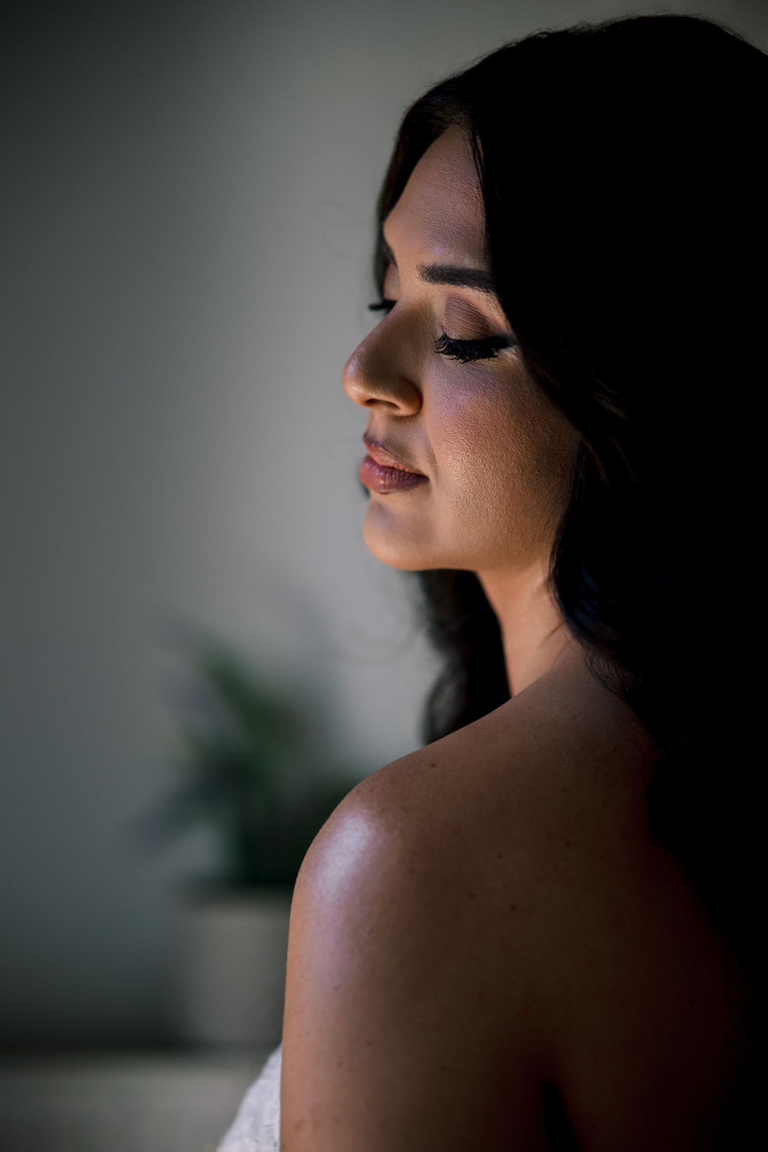 Dramatic side profile portrait in moody lighting and shadows.