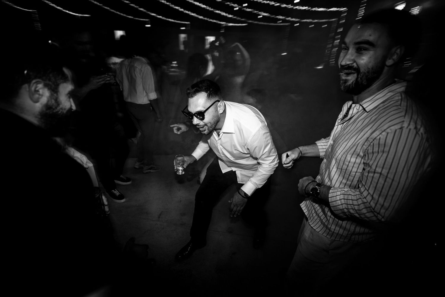 Dark nightclub atmosphere with string lights and dancing silhouettes creating a moody ambiance.