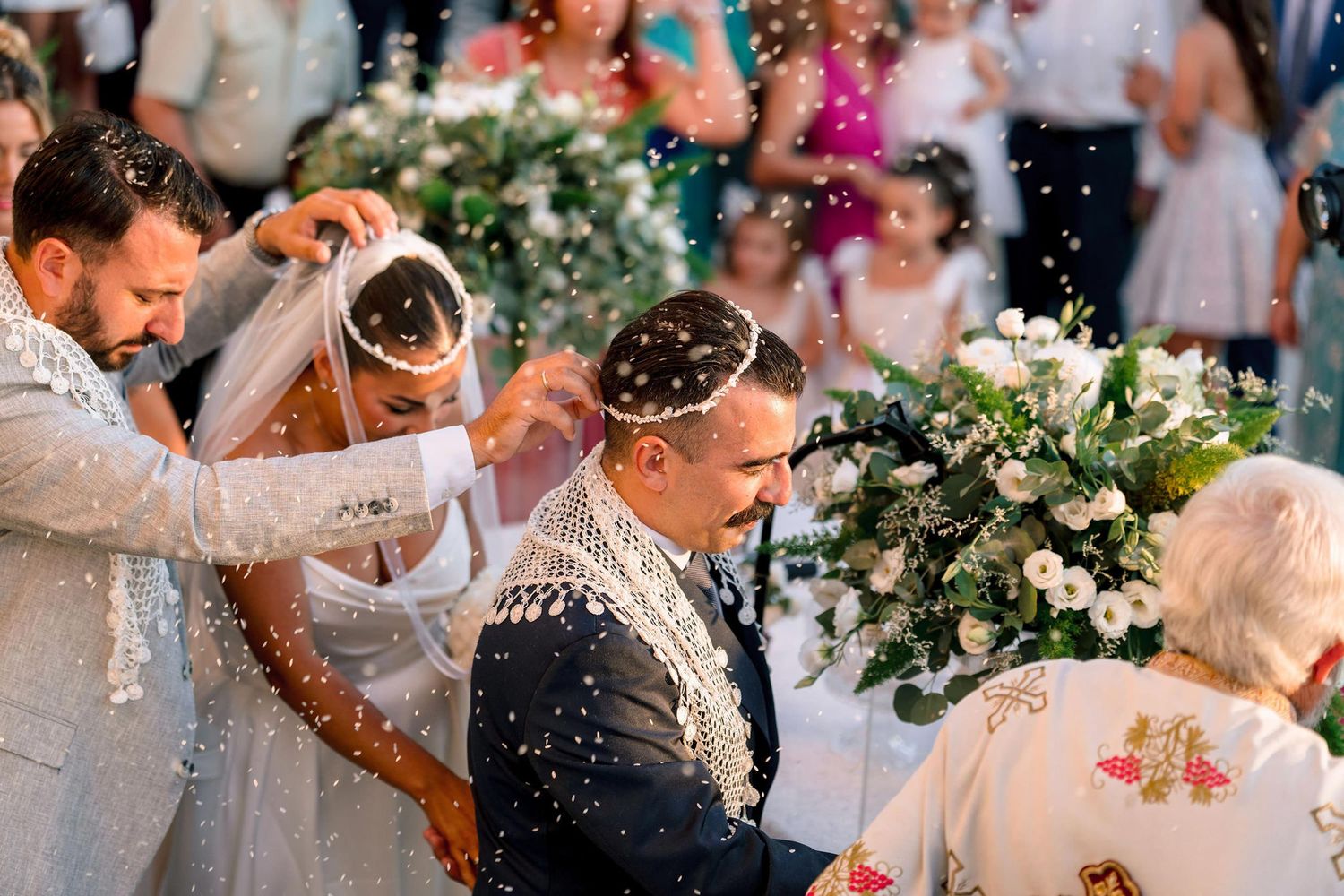 Wedding celebration with confetti being thrown during an outdoor ceremony.