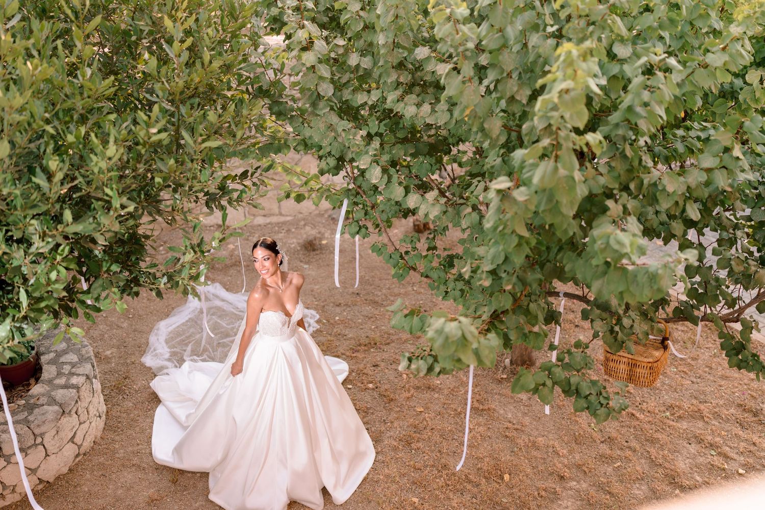 A flowing white wedding dress captured in an outdoor garden setting.